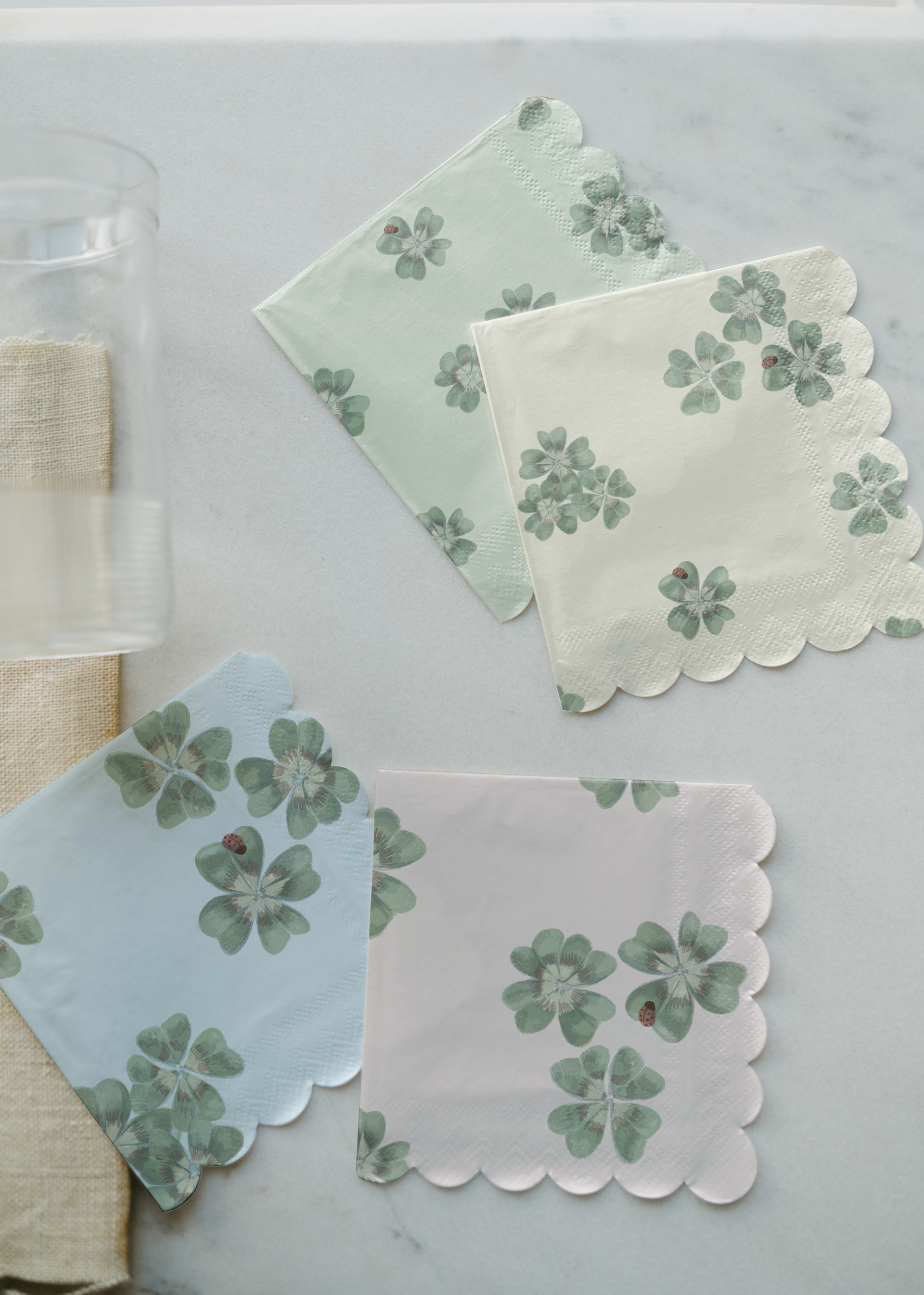   Flat lay of a scallop-edged place mat or tray liner in Clover Scatter cream colourway, styled on a light wooden surface