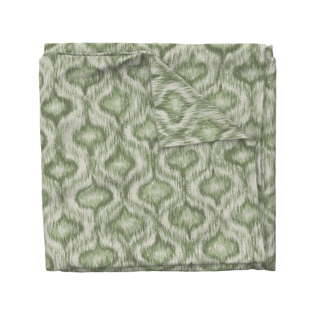 Folded fabric swatch of Boho Style Ikat Ogee in sage green, showing the allover ogee repeat pattern, by Lemon Dessin