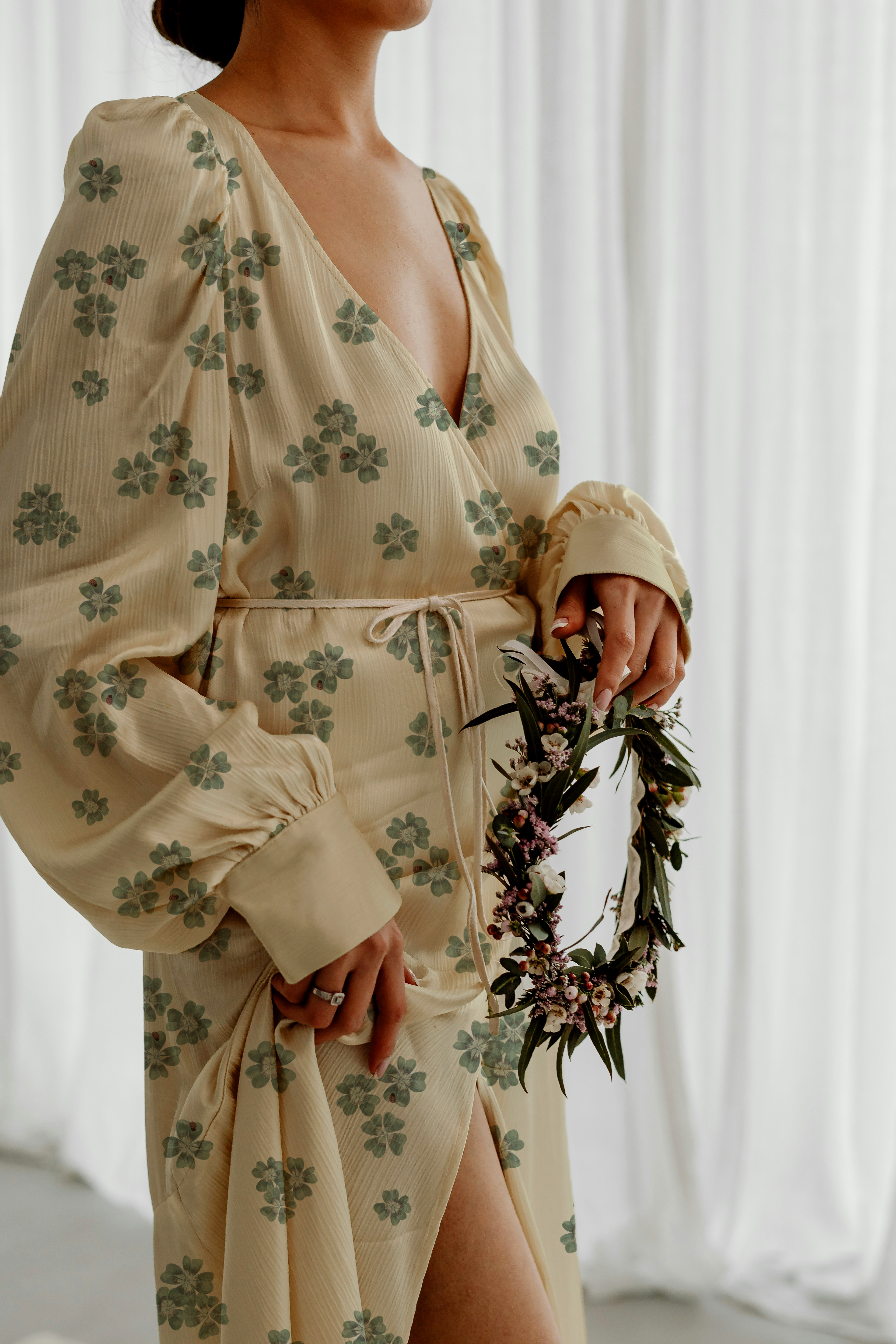 Lifestyle image of a woman wearing a wrap robe in Clover Scatter cream colourway, standing by a white curtain with a flower crown