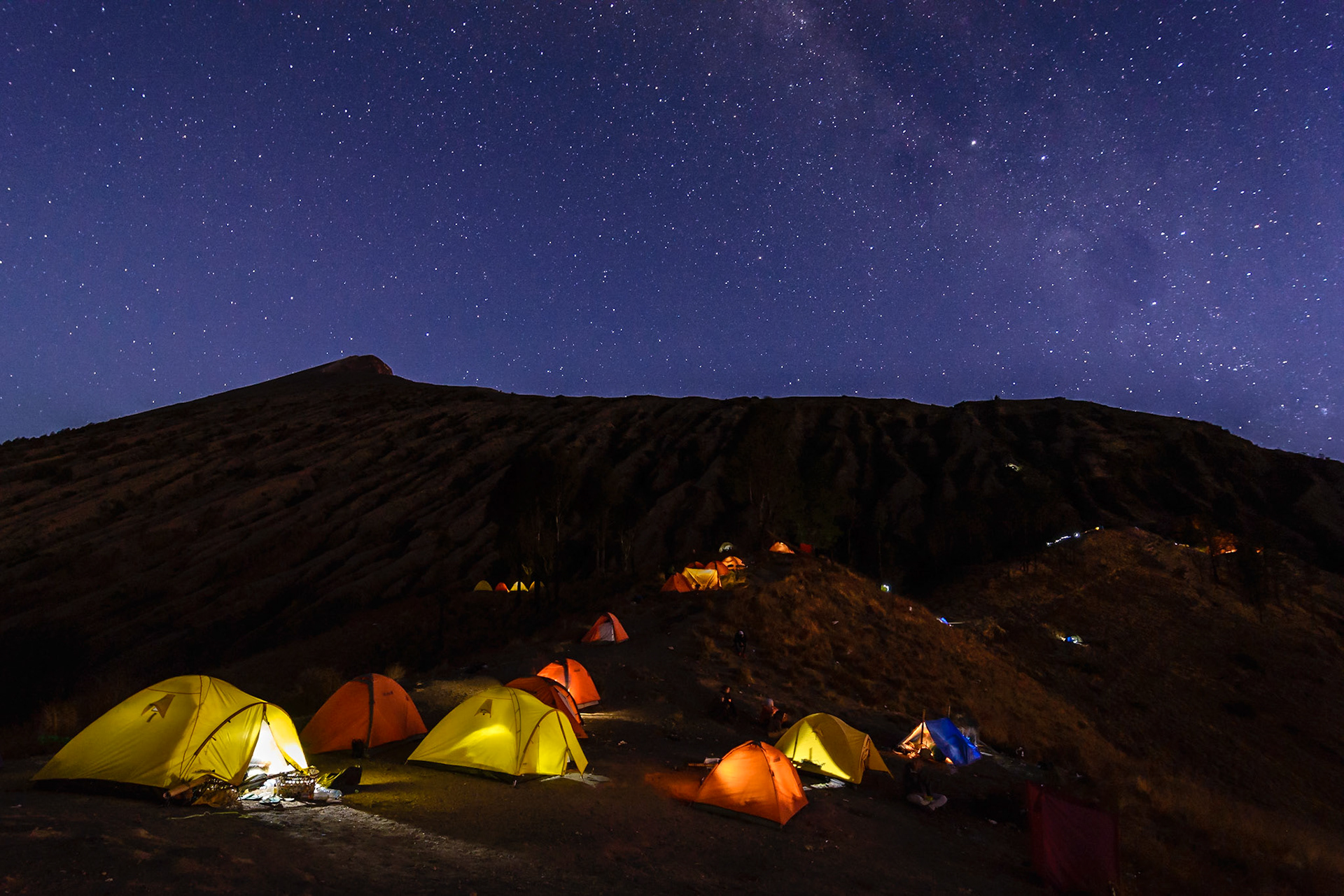 Campsite at the rim of the crater lake (2639m)in the blue hour just after sunset under a clear sky with a view on the milky way. Preparing for the walk to the summit of the volcano (3776m) early next morning.