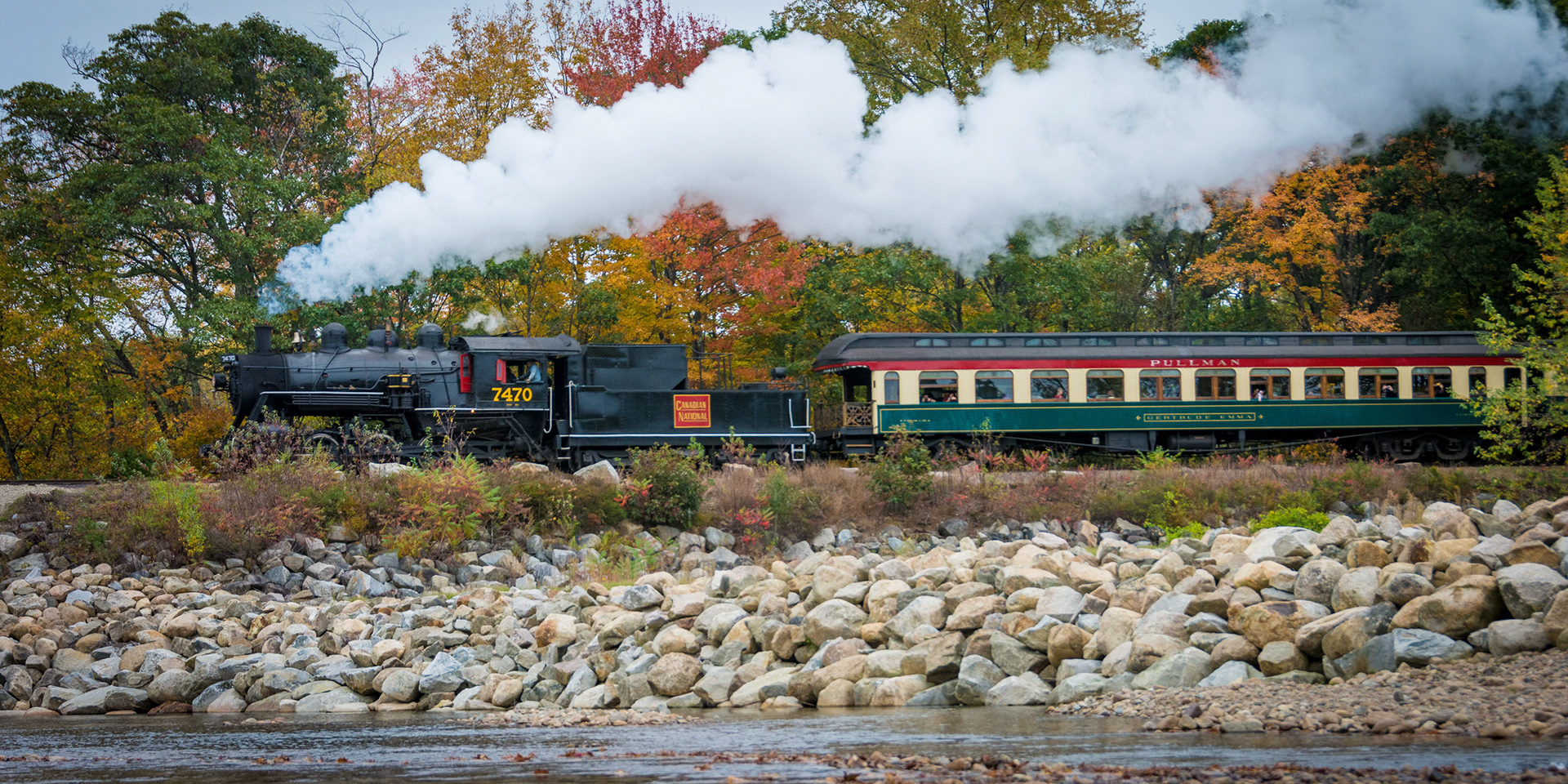 Fall color on the banks of the Swift River as Conway Scenic Railroad Locomotive 7470 steams north with a train full of passengers.