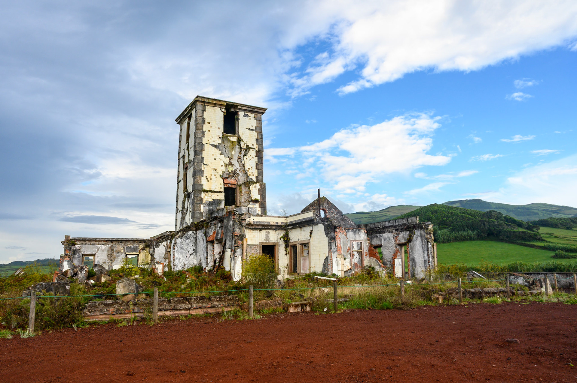 Le phare d'origine se composait d'une tour carrée en maçonnerie de 14 mètres de haut. Le bâtiment annexe, d'un étage, a servi pour le logement des gardiens de phare. Les travaux de construction ont commencé en mai 1915, et le phare a été mis en service le 1er novembre 1919. A cause du tremblement de terre de 1998, la tour et les bâtiments annexes ont subi de lourds dommages, conduisant à sa désactivation. Le tremblement de terre est dû à l'origine d'une faille tectonique sous-marine, à environ 5 km de Ponta da Ribeirinha,