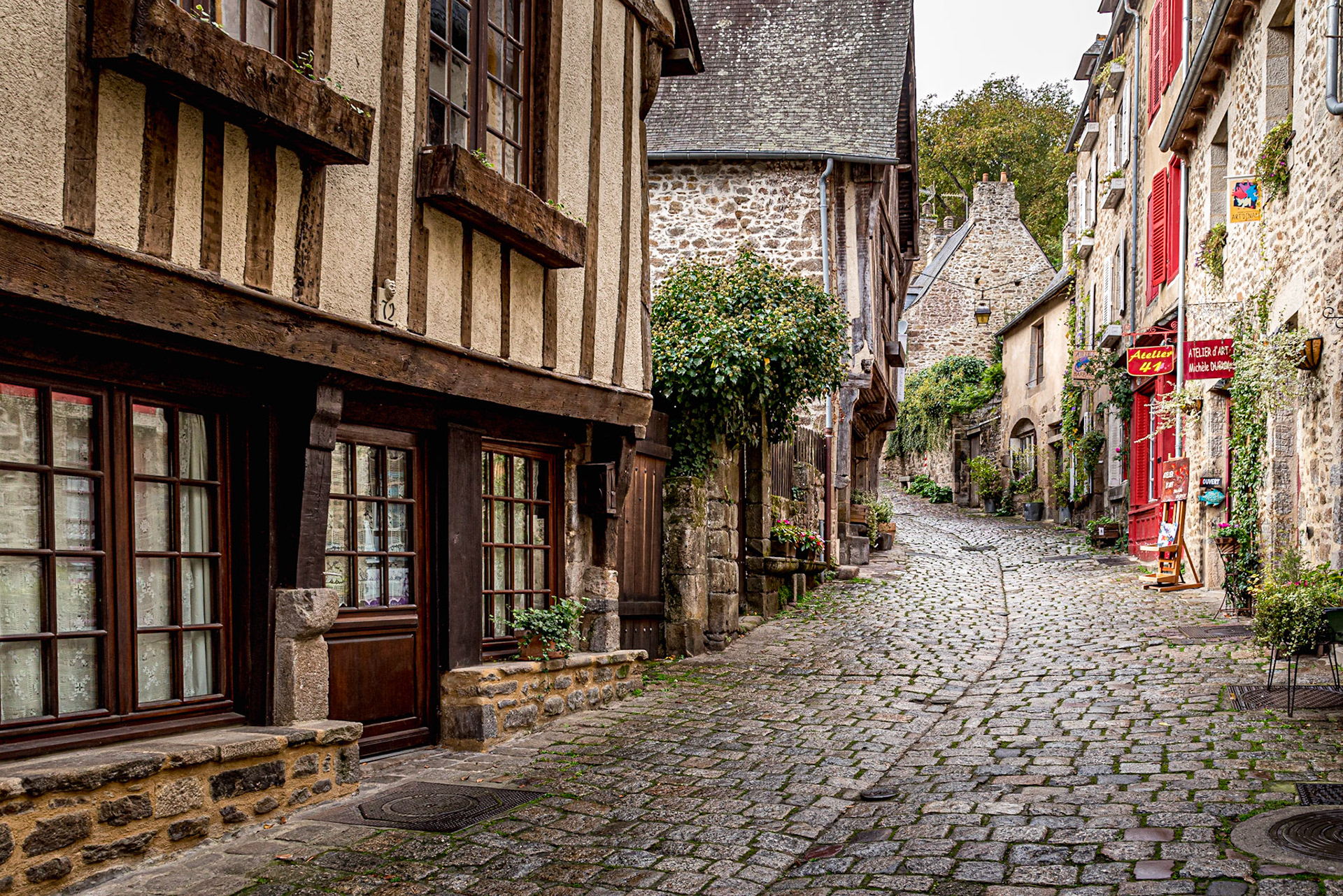 Artère commerciale, pauvre et bruyante jusqu’au XIX ème siècle, la rue la plus ancienne de Dinan est une rue étroite qui chemine depuis le port sur les bords de la Rance jusqu’au centre de Dinan. Pendant des siècles, marchands, voyageurs et manants vont emprunter cette voie unique, extrêmement pentue. Ce lien incontournable entre la ville-haute bourgeoise et la ville-basse commerçante et populaire. Les charrettes à bras, s’y croisent alors dans les deux sens. De nombreuses échoppes jalonnent la ruelle, c’est le passage le plus vivant de la ville. L’axe où transite toute la richesse économique de Dinan.