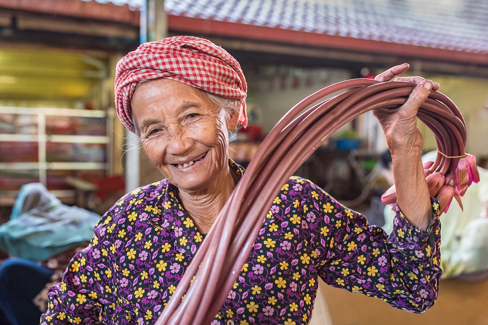 J'ai établi un bon contact avec cette dame très souriante, rencontrée sous la halle du marché de Kampot dans le Sud Ouest du Cambodge. Elle mettait en botte les tiges et fleurs de lotus, avec un entrain qui faisait plaisir à voir, avant de les proposer à la vente. Le Lotus est très présent dans les cultures d'Asie où il est emblématique du bouddhisme et de l'hindouisme.