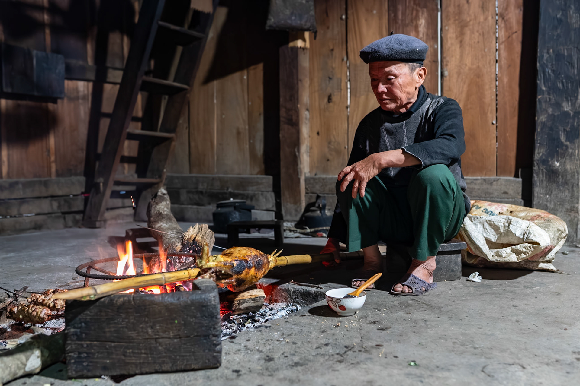 Dans les montagnes du Nord Vietnam, l'ethnie H'mong attache beaucoup d'importance à la qualité et la taille de leur habitat. Pour autant, la cuisine se fait à l'intérieur de la maison, à même le sol dans un espace spécifique et la fumée "traite" les charpentes avant de s'échapper. Notre hôte Mr Soh, chef du village de Seo Lung, est en train de faire cuire le poulet qu'il va nous servir quelques instants plus tard.