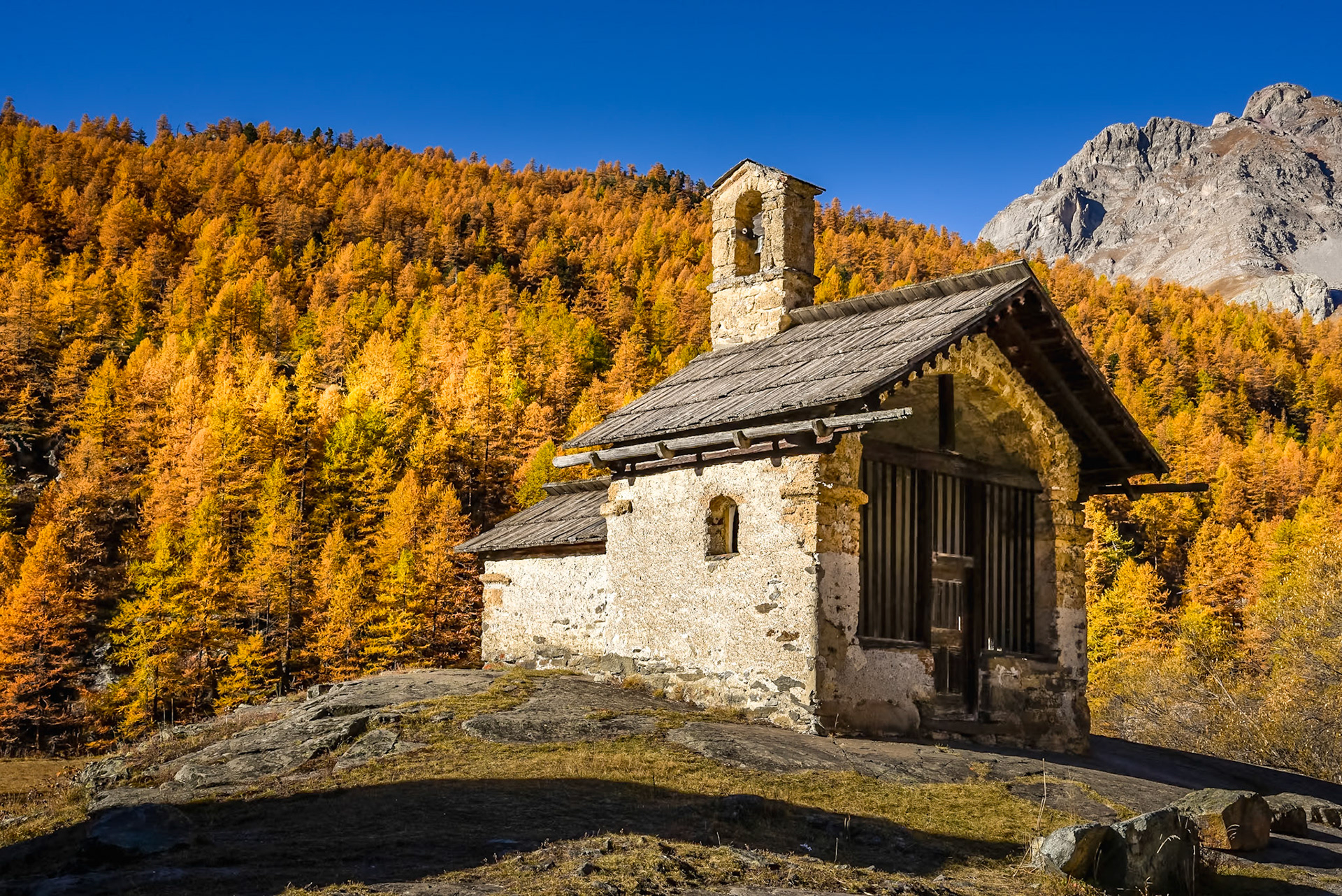 Après Névache, quand vous vous enfoncez dans la vallée de la Haute Clarée, vous arrivez au hameau de Fontcouverte où trône cette belle chapelle. Elle a été construite en 1627 sur un rocher usé, à l'endroit d'une source miraculeuse cachée par des buissons ! D'où son nom de : 'Fontaine couverte'Ici, elle est bien mise en valeur par la jolie lumière d'automnecet les mélèzes en feu