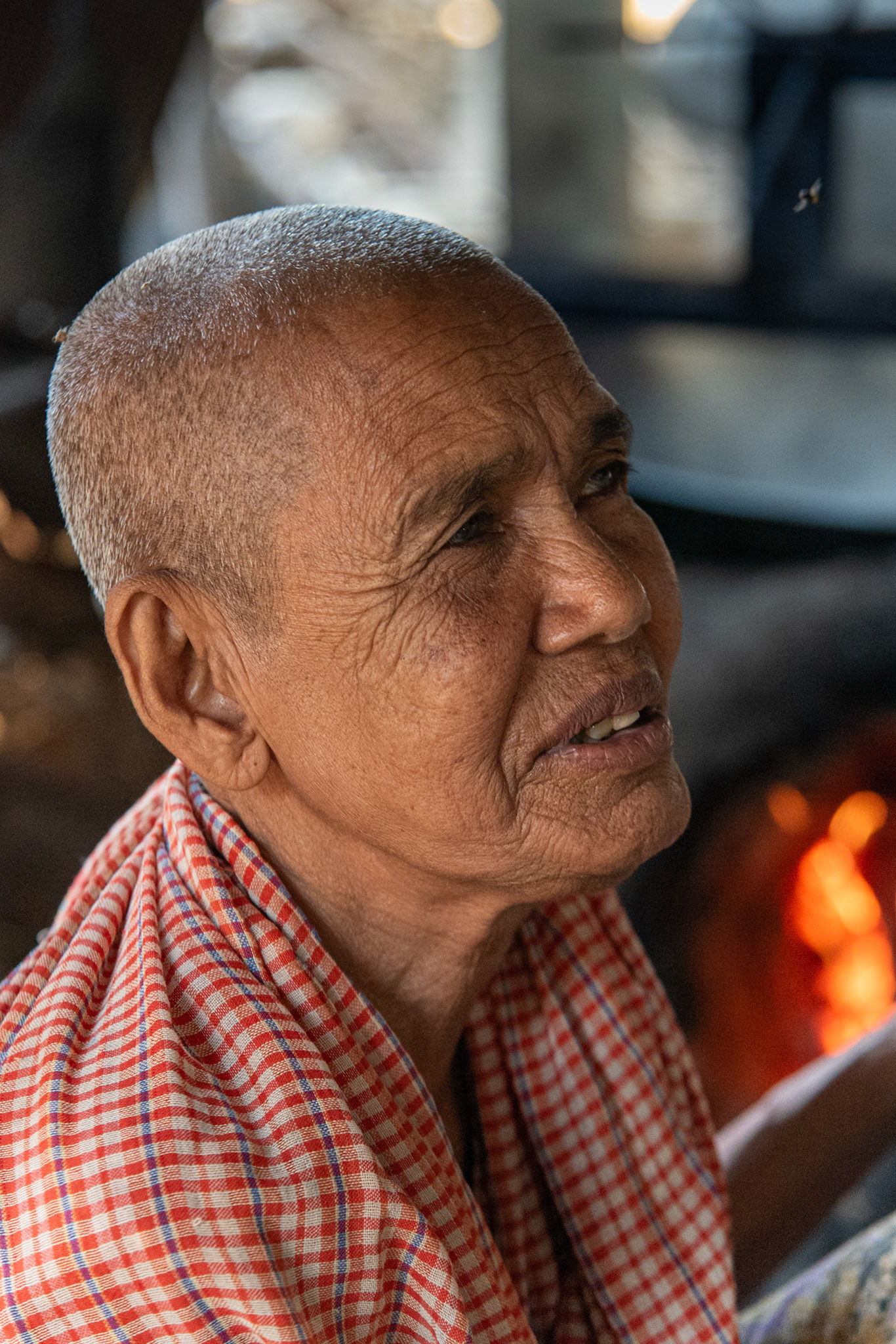 Elle sourit comme on sourit à la chaleur d’un souvenir.  