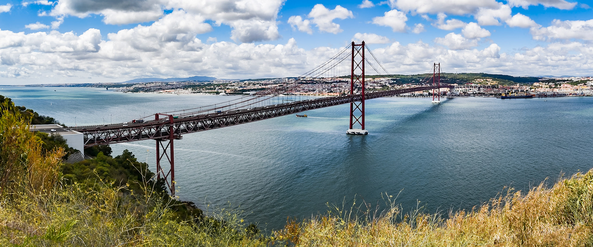 Le pont du 25 avril relie les deux rives du Tage, de Lisbonne à Almada (ville où se situe le Christ Roi). Le pont est construit entre 1962 et 1966, et est inauguré sous le nom de “Pont Salazar”. Il gardera ce nom jusqu’au 25 avril 1974, jour de la révolution des oeillets entraînant la chute de la dictature de Salazar.