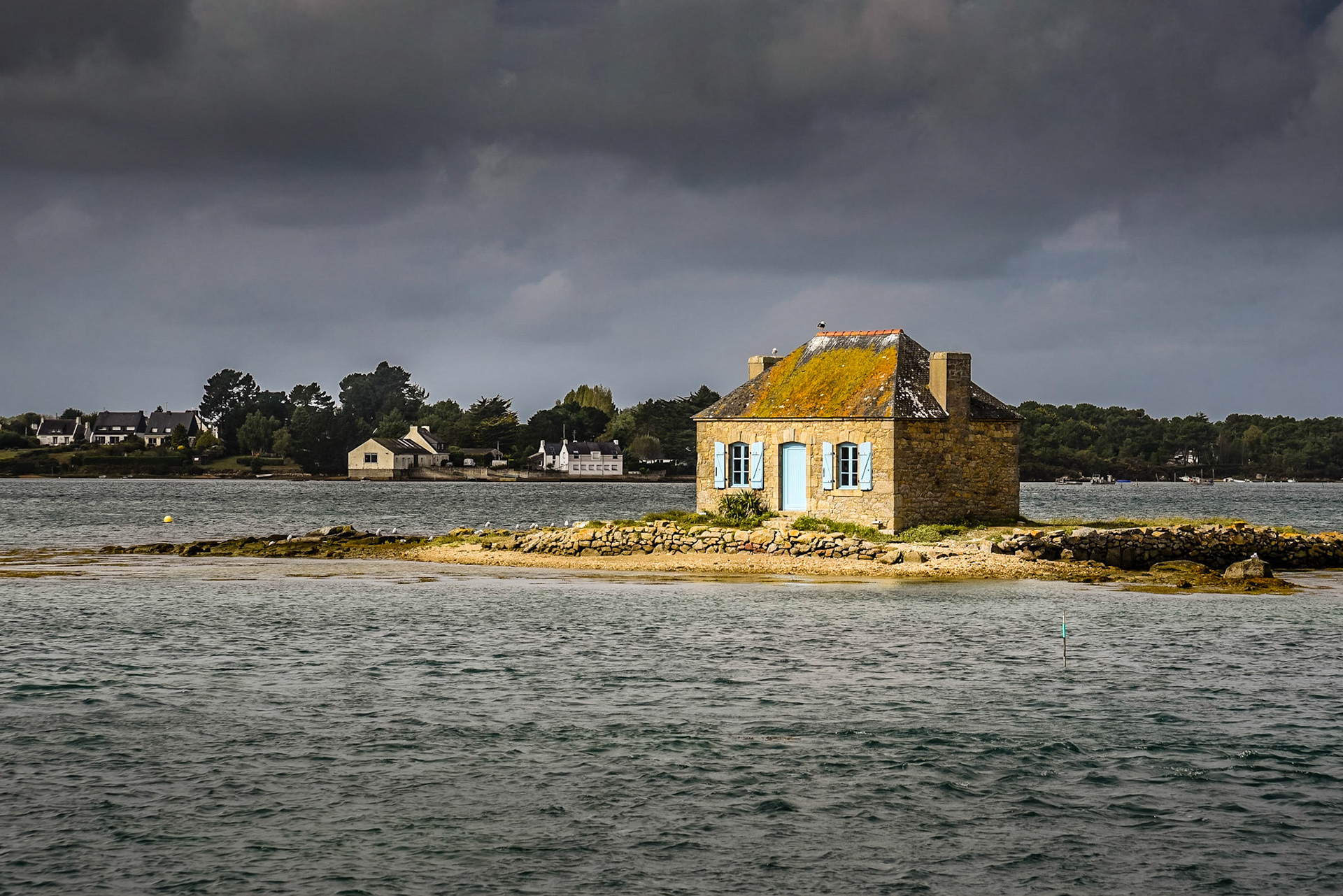 Construite vers 1890, à l’initiative d’un gros négociant Etellois qui voulait se lancer dans l’ostréiculture. Ayant différents parcs ostréicoles dans la Ria, notamment autour de l’îlot, il avait souhaité construire pour y abriter un gardien de parcs et sa famille.Les différents gardiens ont profité d’un bail délivré par l’Etat car  la maison fait partie du domaine maritime qui est inaliénable. Depuis de nombreuses années, la mairie de Belz s’occupe de l’entretien de la célèbre petite maison aux volets bleus, joyau de la Ria d’Etel.