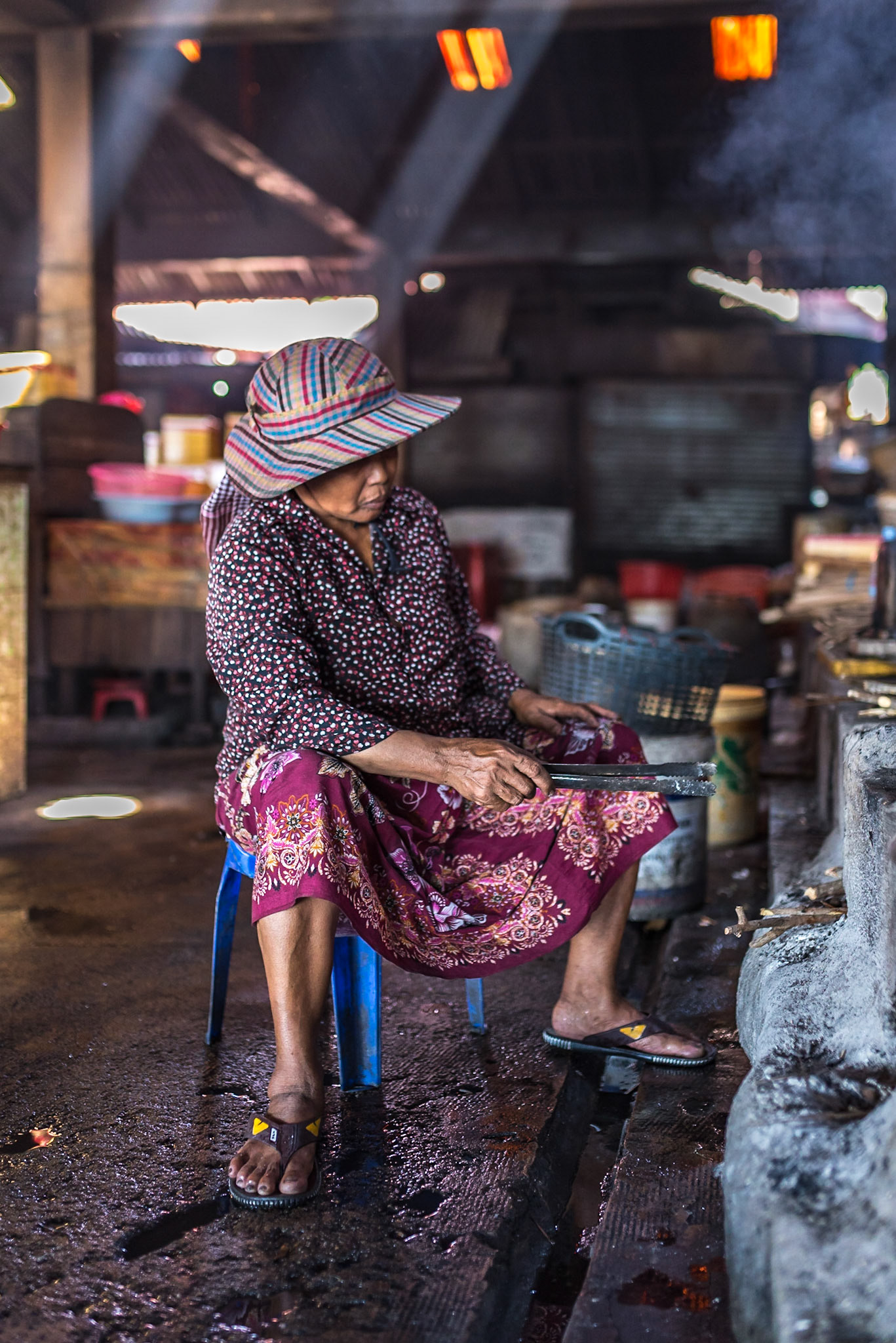Elle cuisine à même le sol, dans l’ombre fraîche des gestes répétés.  