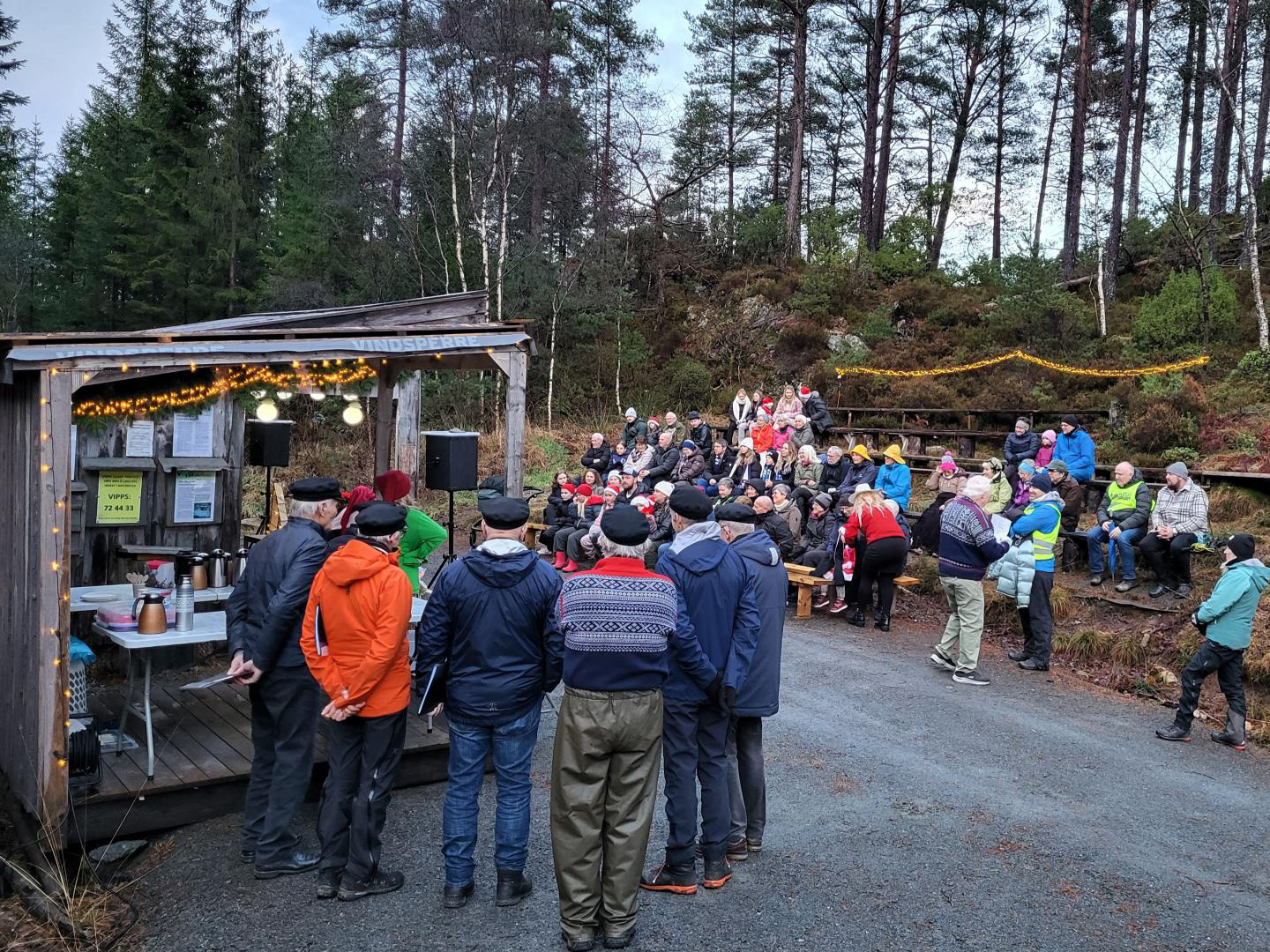 Folket finn plassane sine, og Shantykoret har funne sine, framfor ei av salsbuene. Foto Hildegunn Ruud.