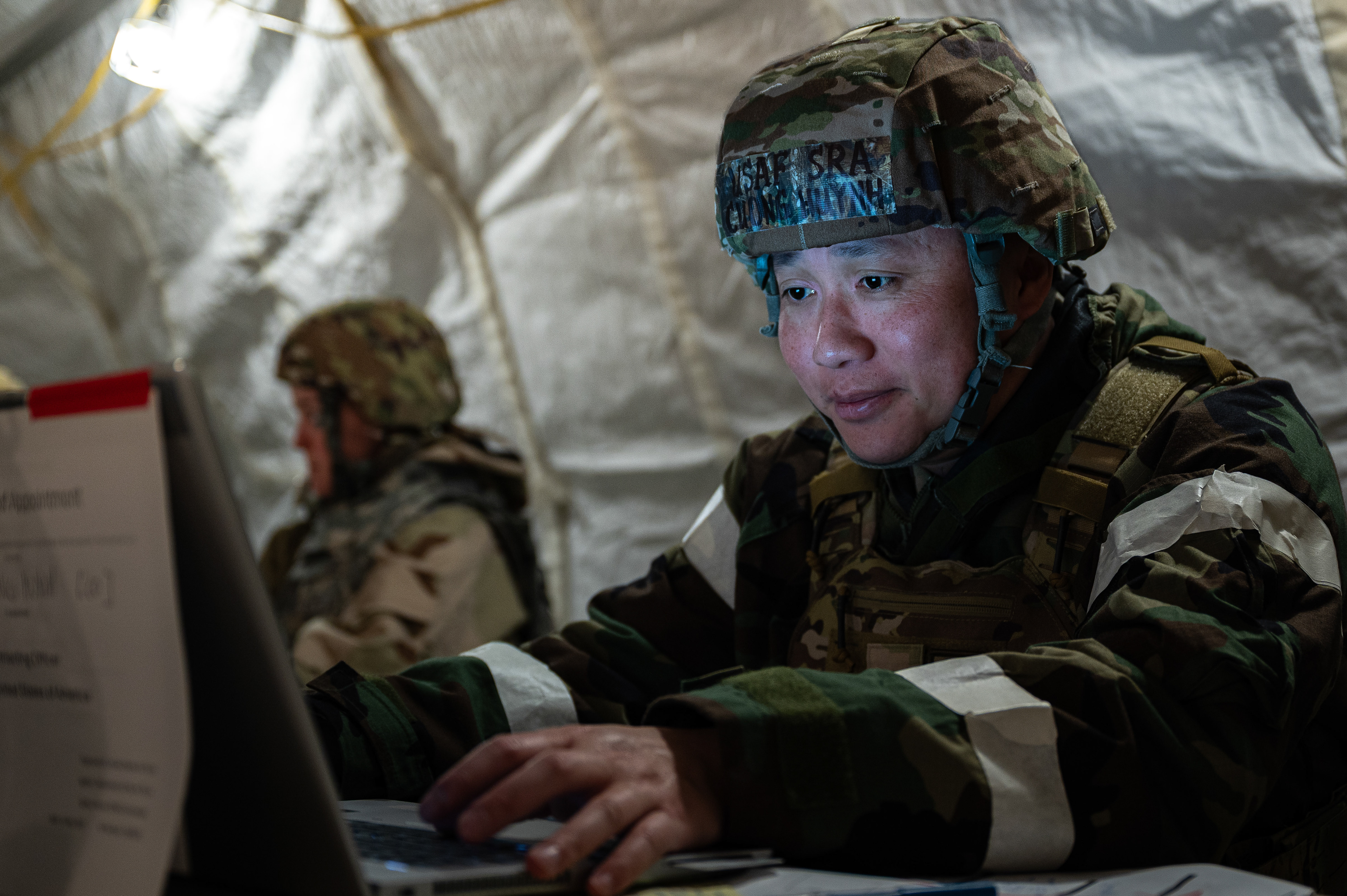 U.S. Air Force Airman Huynh Cuong, 4th Contracting Squadron contracting specialist, operates a laptop inside a field tent during an Integrated Contingency Training at Seymour Johnson Air Force Base, North Carolina, May 20, 2025. Cuong supported a simulated deployment by managing contract operations in an expeditionary environment.