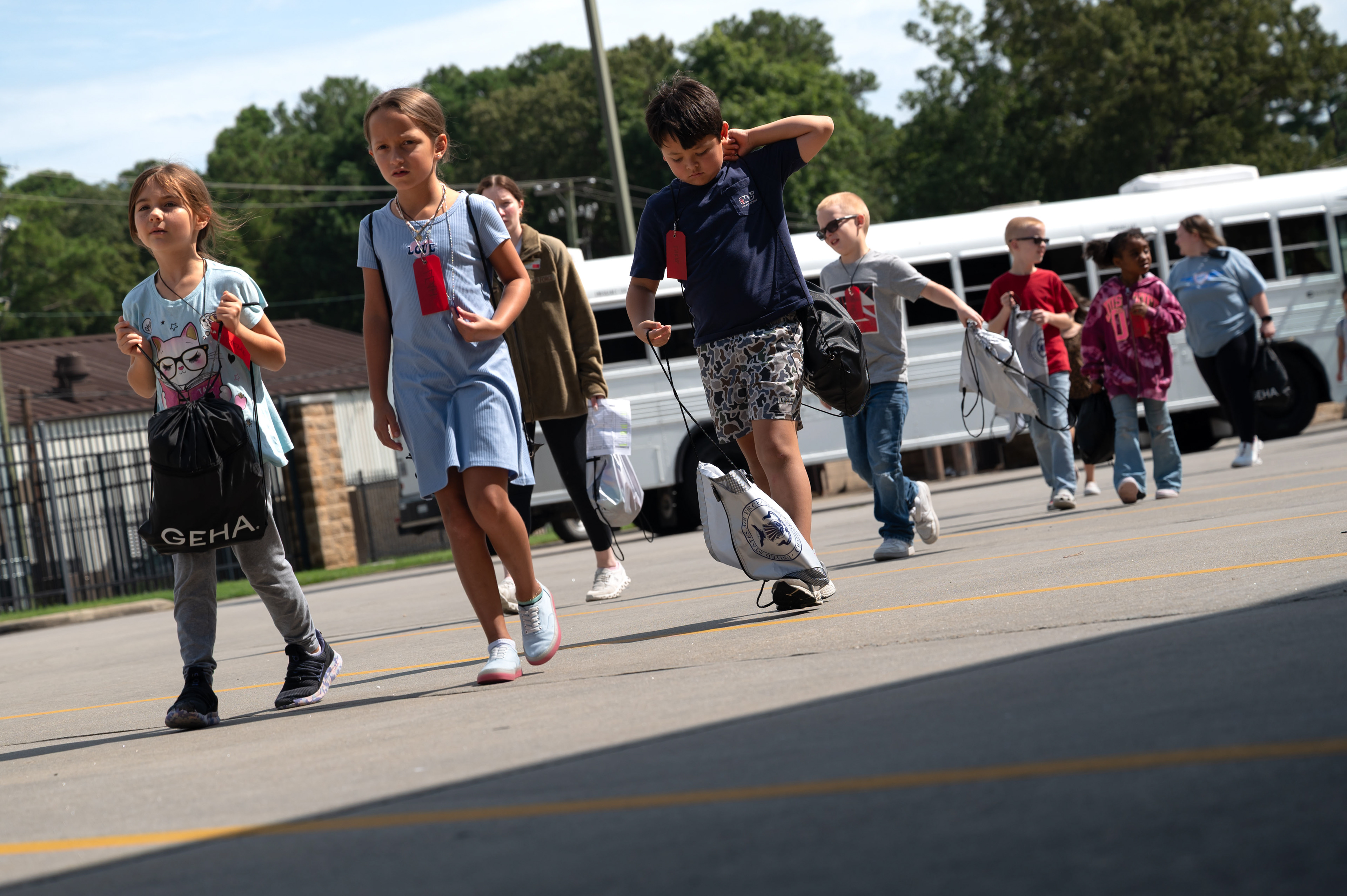 Children exit a bus during Operation Bugout at Seymour Johnson Air Force Base, North Carolina, Aug. 14, 2025. The bus transported participants to a simulated deployment location at the fire station. 