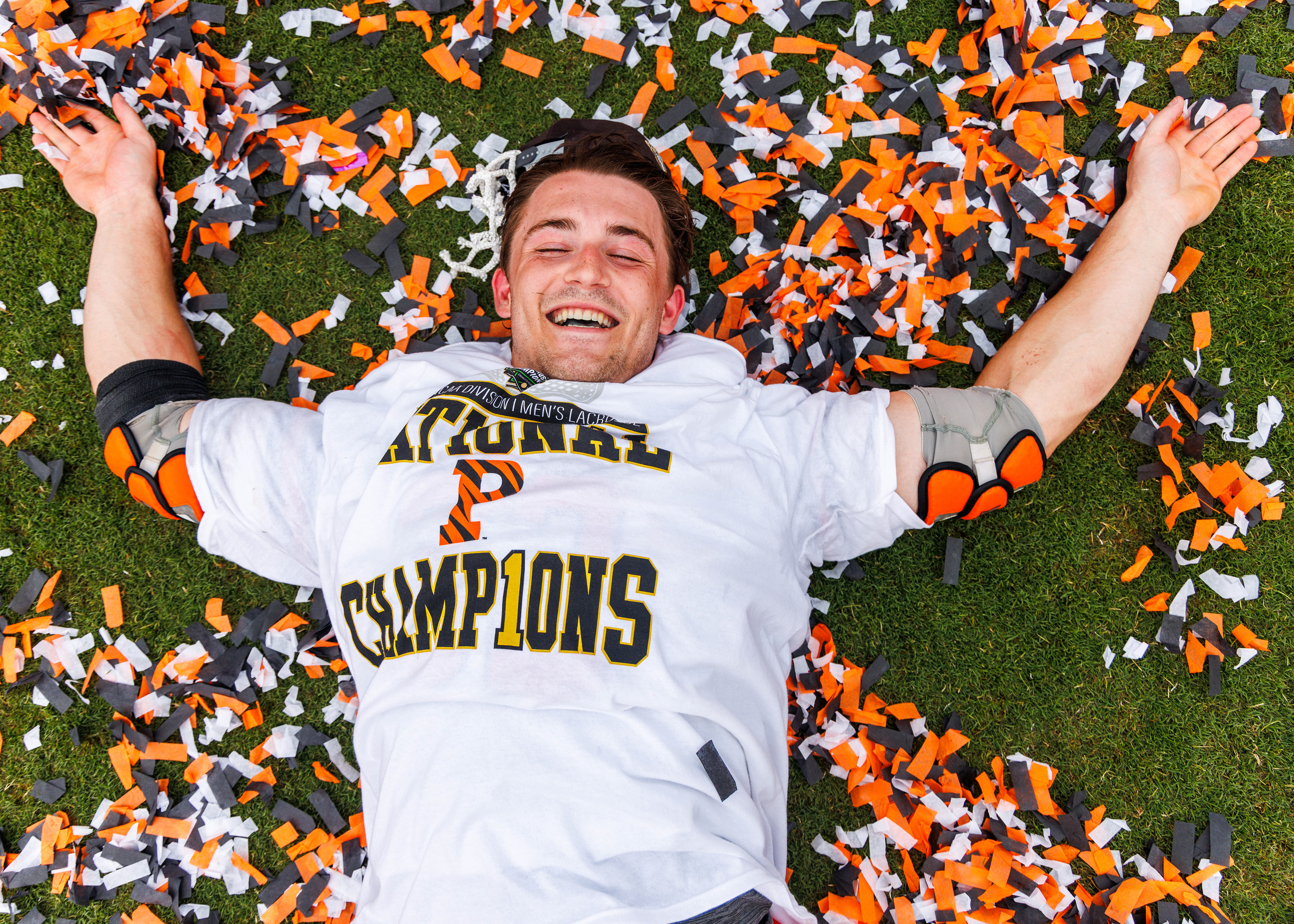 A Princeton Tigers lacrosse player lays in confetti after defeating the Notre Dame Fighting Irish 16-9 to win the NCAA Division I Men's Lacrosse Championship at Scott Stadium on May 25, 2026.  (Photo by Miles Lineberger / First Class Lacrosse)