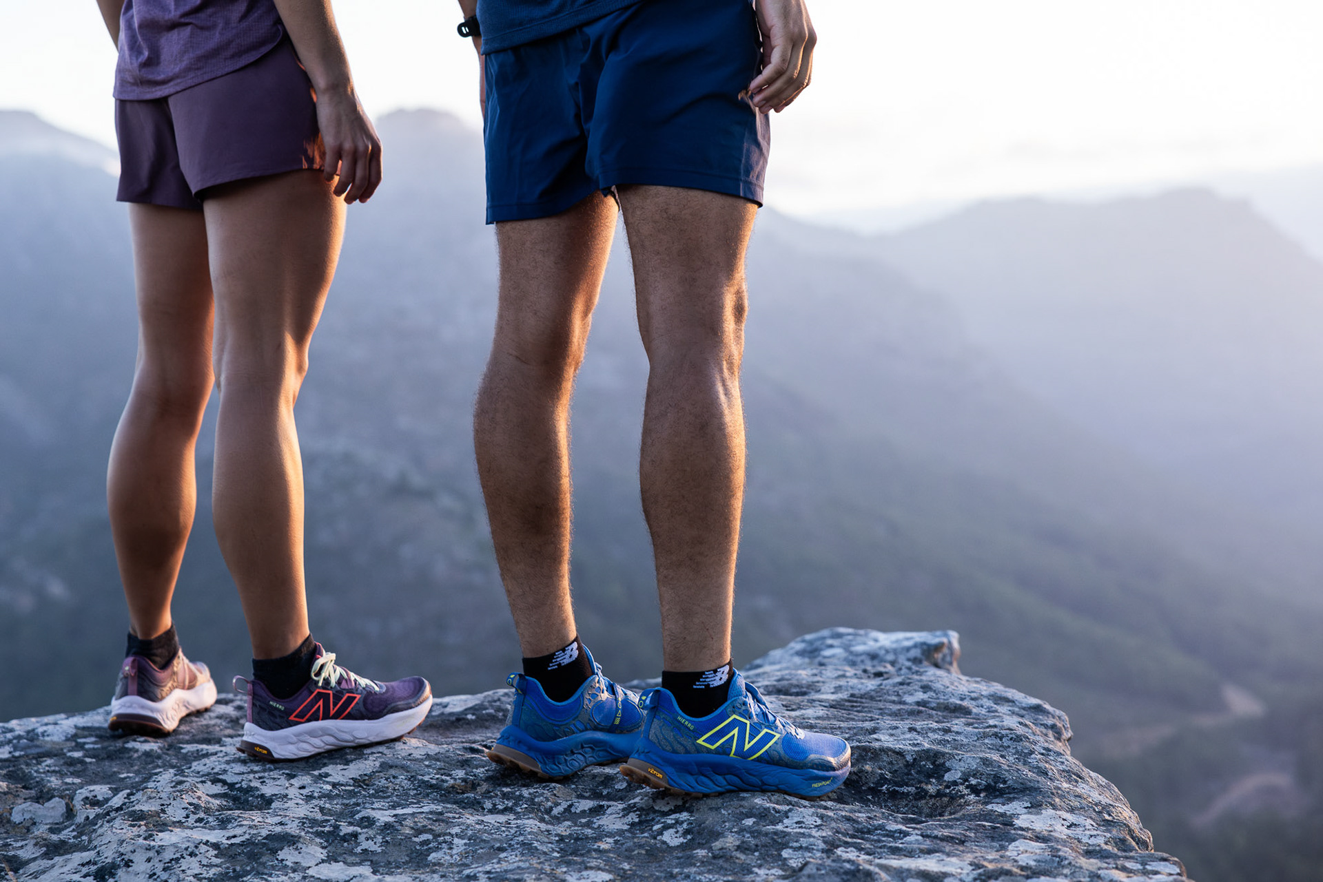 A close up of two trail runners in Cape Town wearing New Balance Fresh Foam X Hierro V8 trail shoes summating a mountain ledge photographed by Casey Crafford