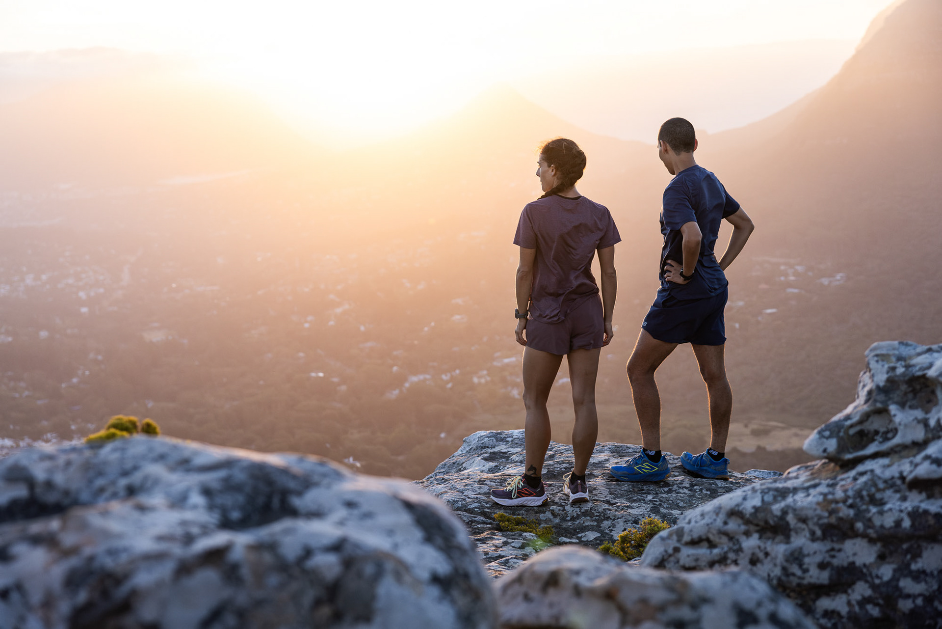 Two trail runners in Cape Town wearing New Balance Fresh Foam X Hierro V8 trail shoes summating a mountain ledge photographed by Casey Crafford