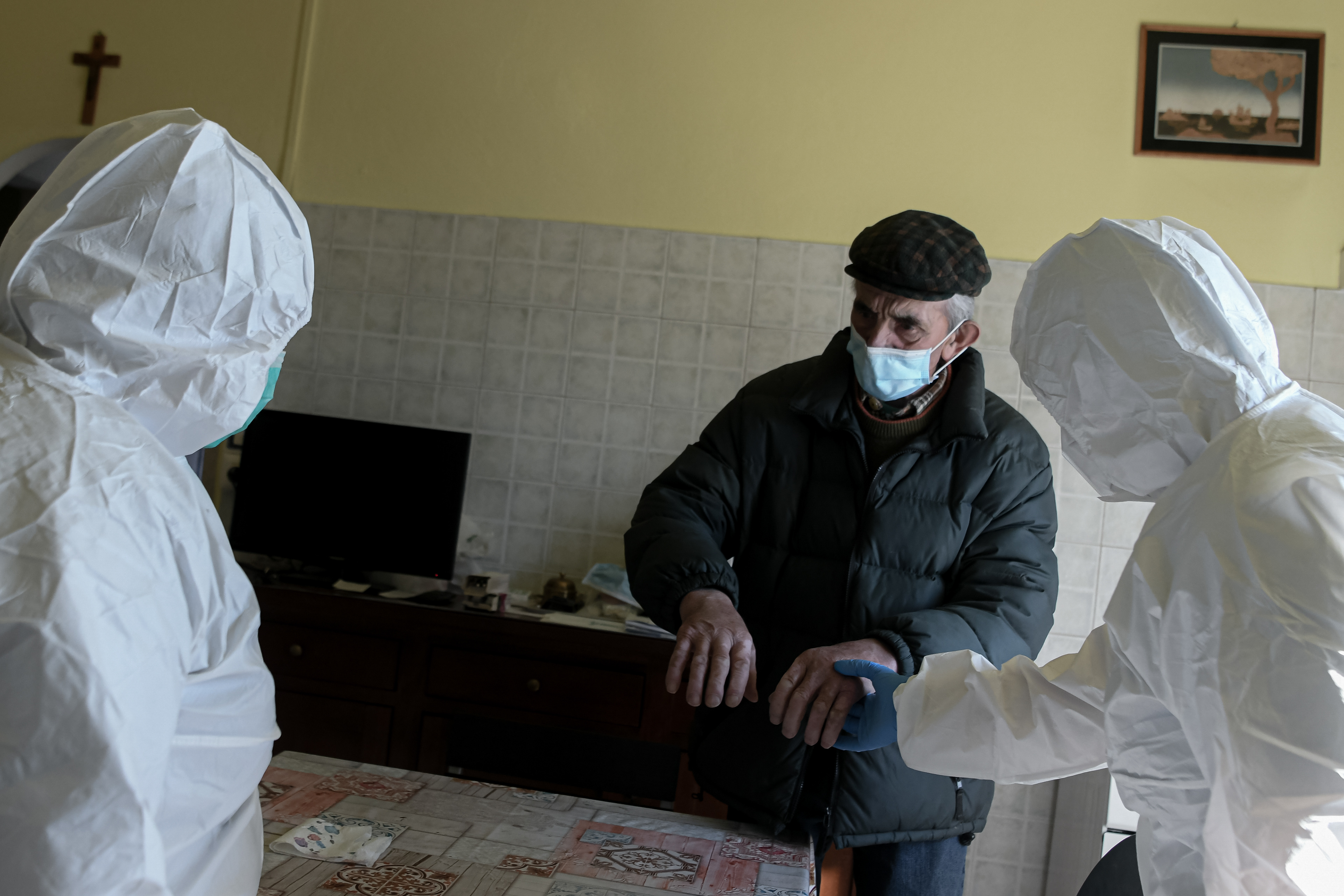 aura, a nurse volunteering for AVAP, a local volunteers association, checks the hands of Onelio, 85, recovering at home from a broken rib, in Palagano (MO), Italy on April 9, 2020.