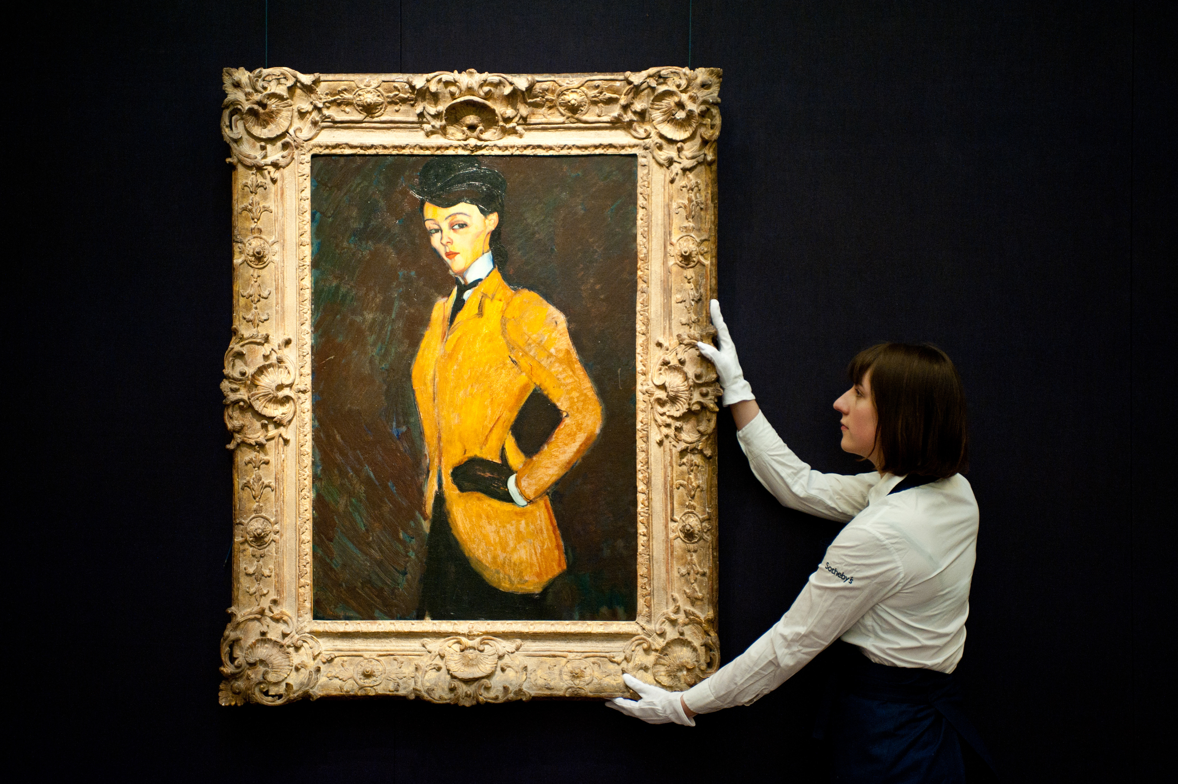 London, UK - 12 April 2013: A Sotheby's employee poses in front of Amedeo Modigliani 'L'Amazone' (Est. $20-30 million). The work will go on sale at Sotheby's New York in May 2013. The Blockbuster sales at include works by Richter, Modigliani, Picasso, Rodin, Bacon, Cezanne. Fotografo a Milano - Photographer Milan