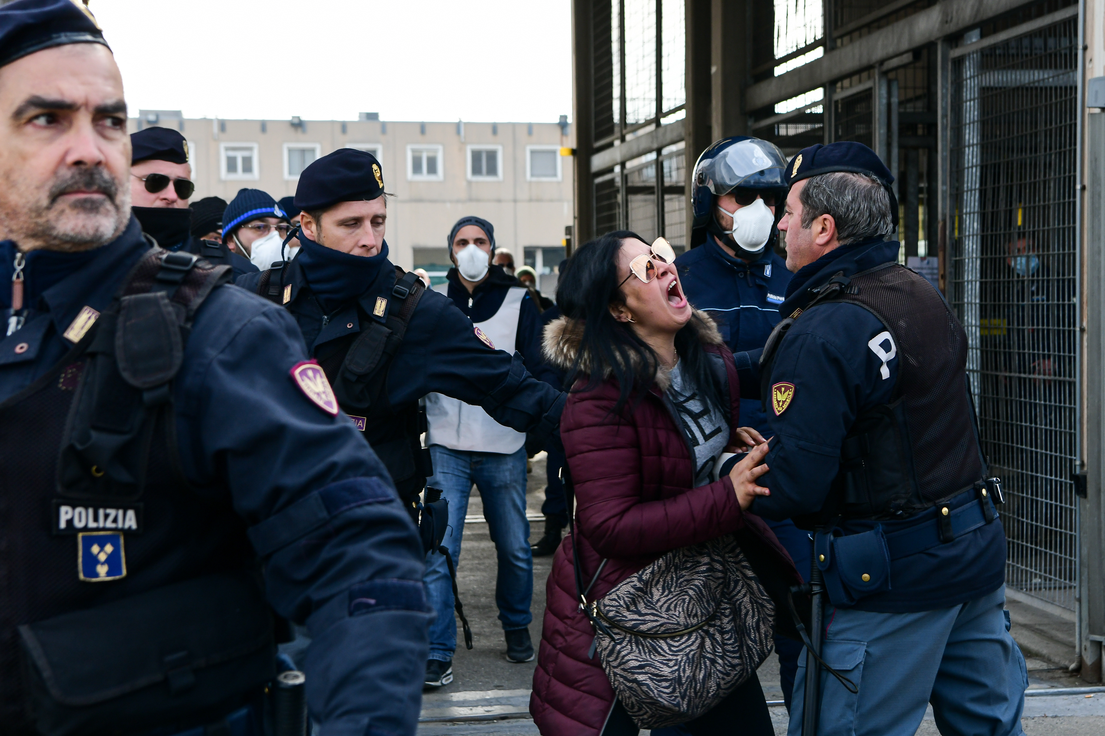 A woman shouts in protests outside Sant’Anna prison in Modena on 9 March 2020. 5 men on Sunday after a riot broke out when inmates were informed that a new decree bans visits and contacts between prisoners and relatives in order to reduce the risk of infection by Coronavirus