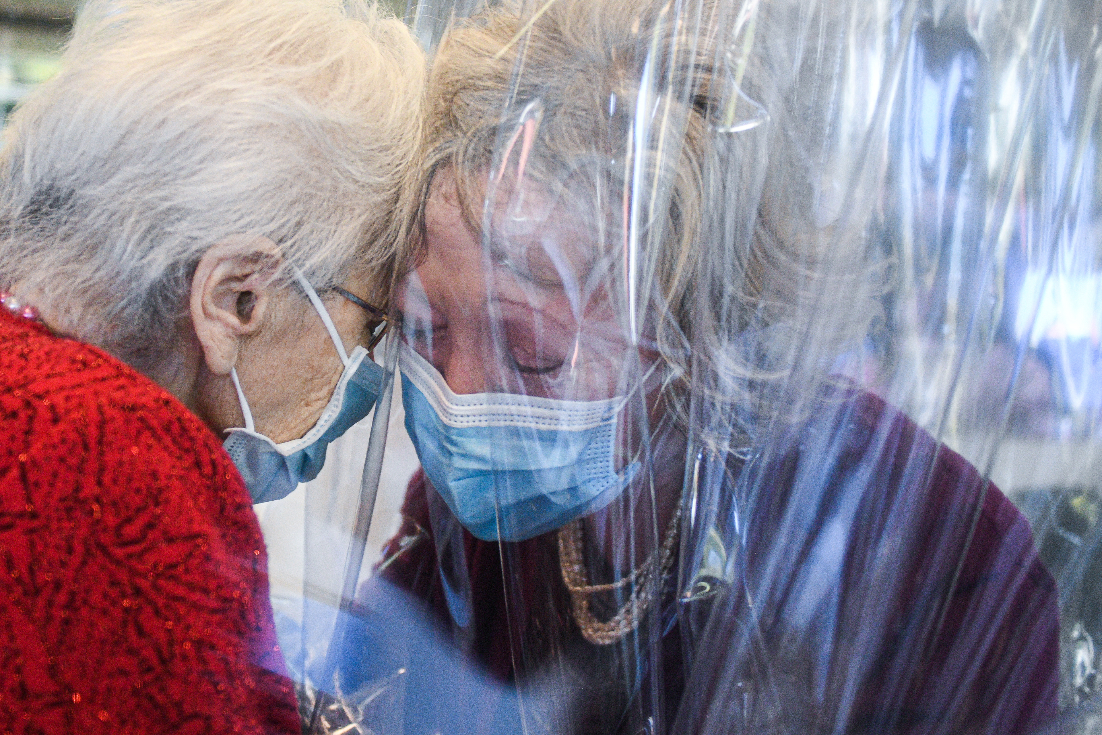 A resident of the Domenico Sartor nursing home hugs her daughter through a plastic screen to avoid the spreading of the Coronavirus Covid-19 disease in Castelfranco Veneto, TV, Italy on 11 November, 2020 - AFP Photo