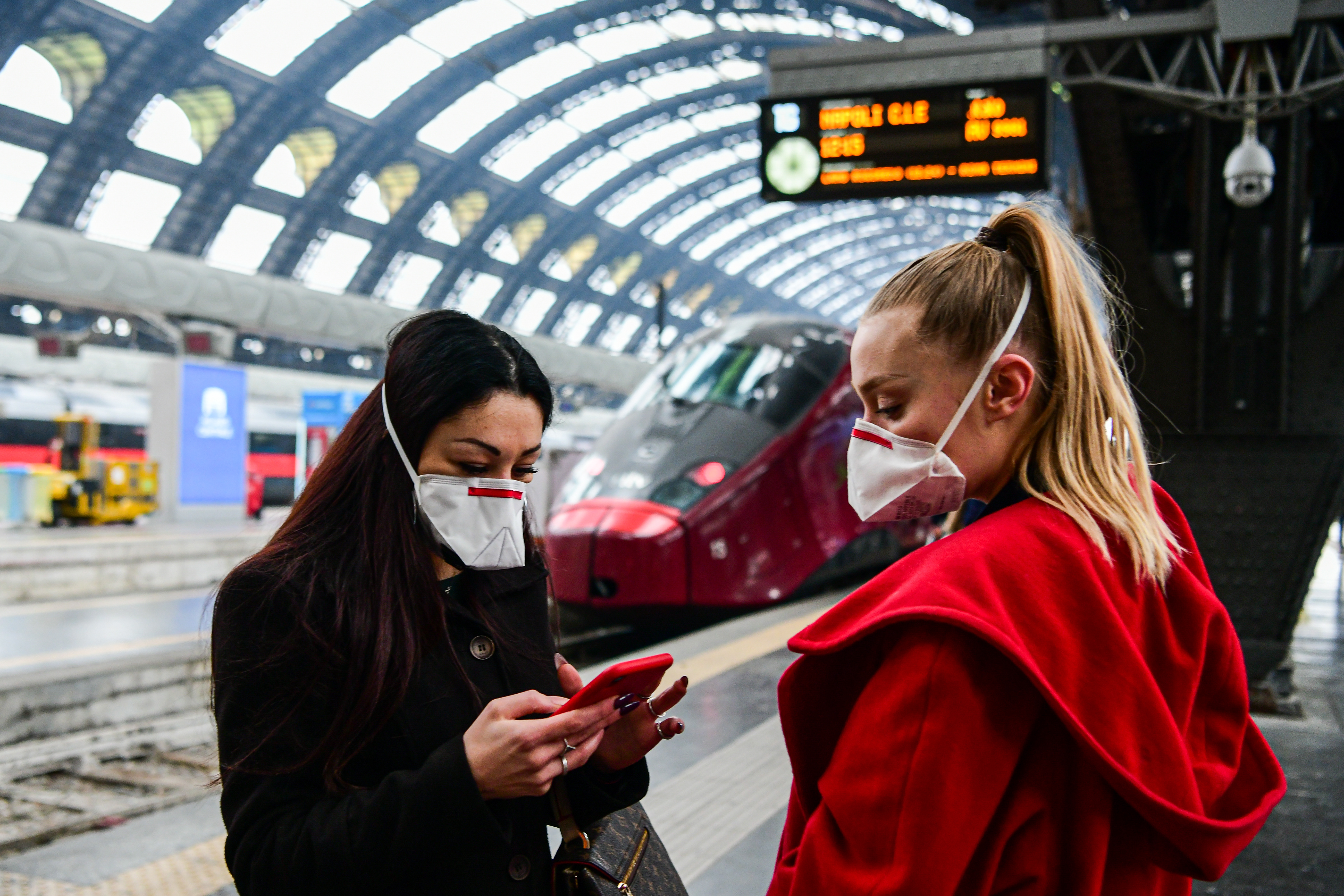 Milan, Italy - 25 February 2020: Passengers at Milano Centrale Train Station wear protective respiratory masks as restrictive measures are taken to contain the outbreak of Coronavirus COVID-19