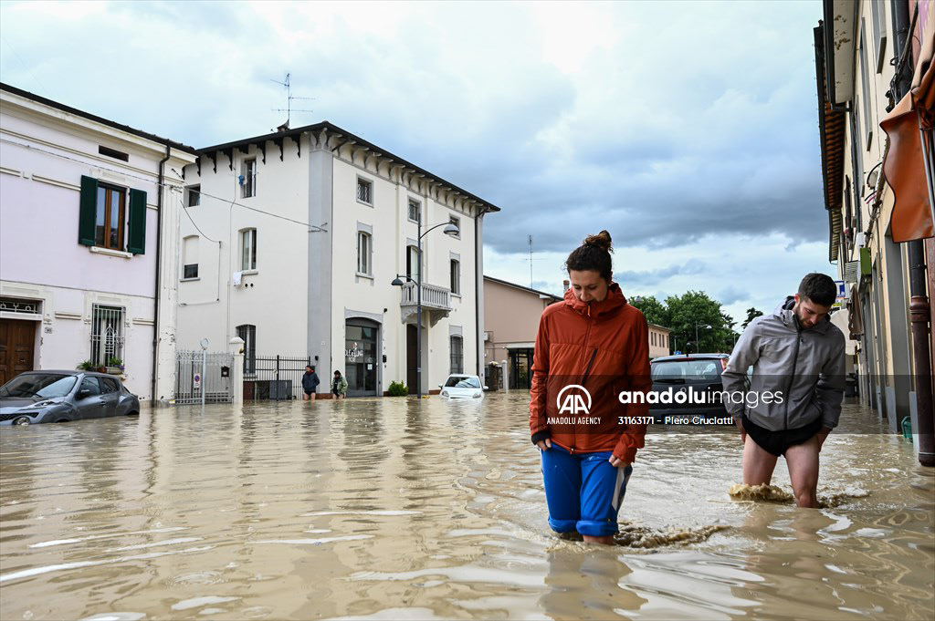 CASTEL BOLOGNESE, ITALY - MAY 17: Pedestrians walk in a flooded street in Castel Bolognese, near Imola, Italy on May 17, 2023. At least three people were killed and thousands of others displaced after torrential rains poured over the northern Italian region of Emilia Romagna, local authorities said on Wednesday. Fotografo a Milano - Photographer Milan