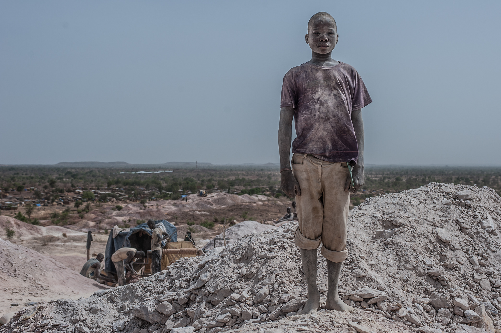 Nobsin, Burkina Faso - 13 May 2014: Abdou, 15, poses for a portrait at the gold extraction site. The youngest ones, small enough to reach the bottom of the mine shafts, are most often the victims of the recurrent accidents. Facing repeated physical and ver- bal violence, drinking alcohol and taking heavy drugs, without any aspiration to get an education, these small boys trying their luck with gold, are the most worri- some aspect of the Burkinabè artisanal gold rush.