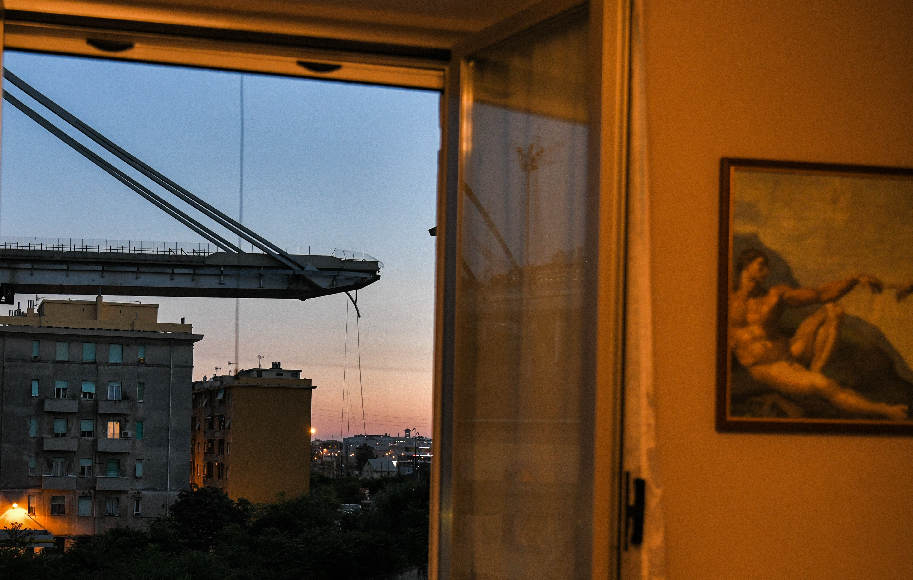 A general view of the houses underneath the Morandi motorway bridge after a section collapsed earlier in Genoa on August 15, 2018. - At least 30 people were killed on August 14 when the giant motorway bridge collapsed in Genoa in northwestern Italy. The collapse, which saw a vast stretch of the A10 freeway tumble on to railway lines in the northern port city, was the deadliest bridge failure in Italy for years, and the country's deputy transport minister warned the death toll could climb further. Piero Cruciatti / AFP Fotografo Milano. Photographer Milan