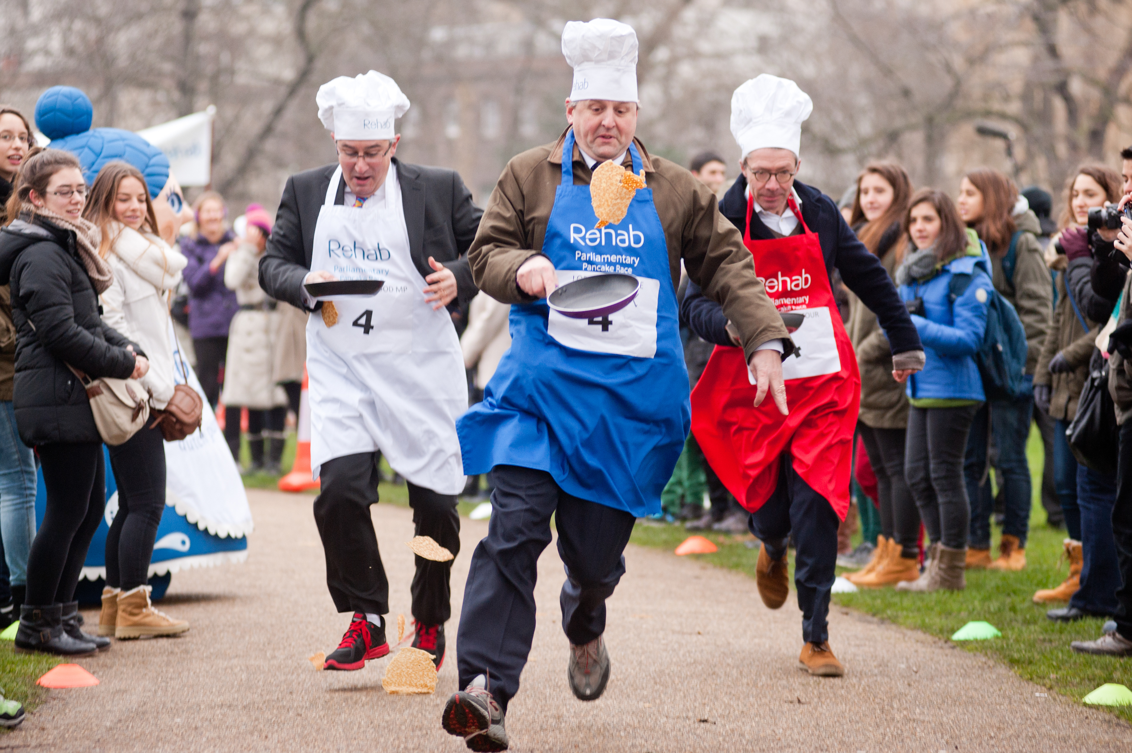 London, UK - 12 February 2013: the 16th Parliamentary Pancake Race takes place next to the Houses of Parliament on Shrove Tuesday raising money for the charity Rehab. Politicians and MPs toss pancakes into the air and catch them in the pan whilst running.The team of MPs has won the event this year. Fotografo Milano - Photographer Milan