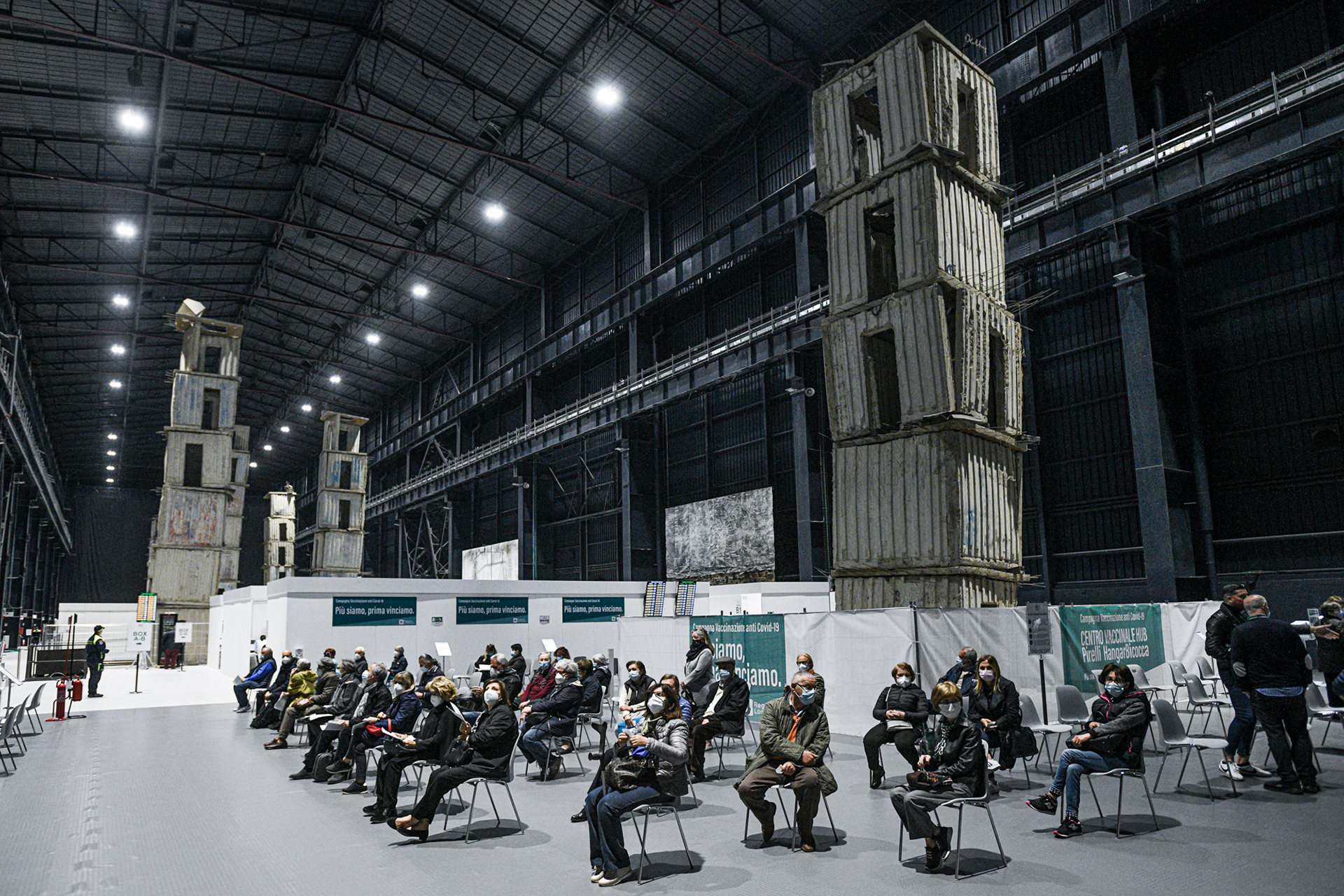 People wait at the mass covid-19 vaccination hub coordinated by ASST Nord Milano opening today at “Pirelli HangarBicocca” where the monumental site-specific art installation ‘The Seven Heavenly Palaces 2004-2015’ by artist Anselm Kiefer is on display.
