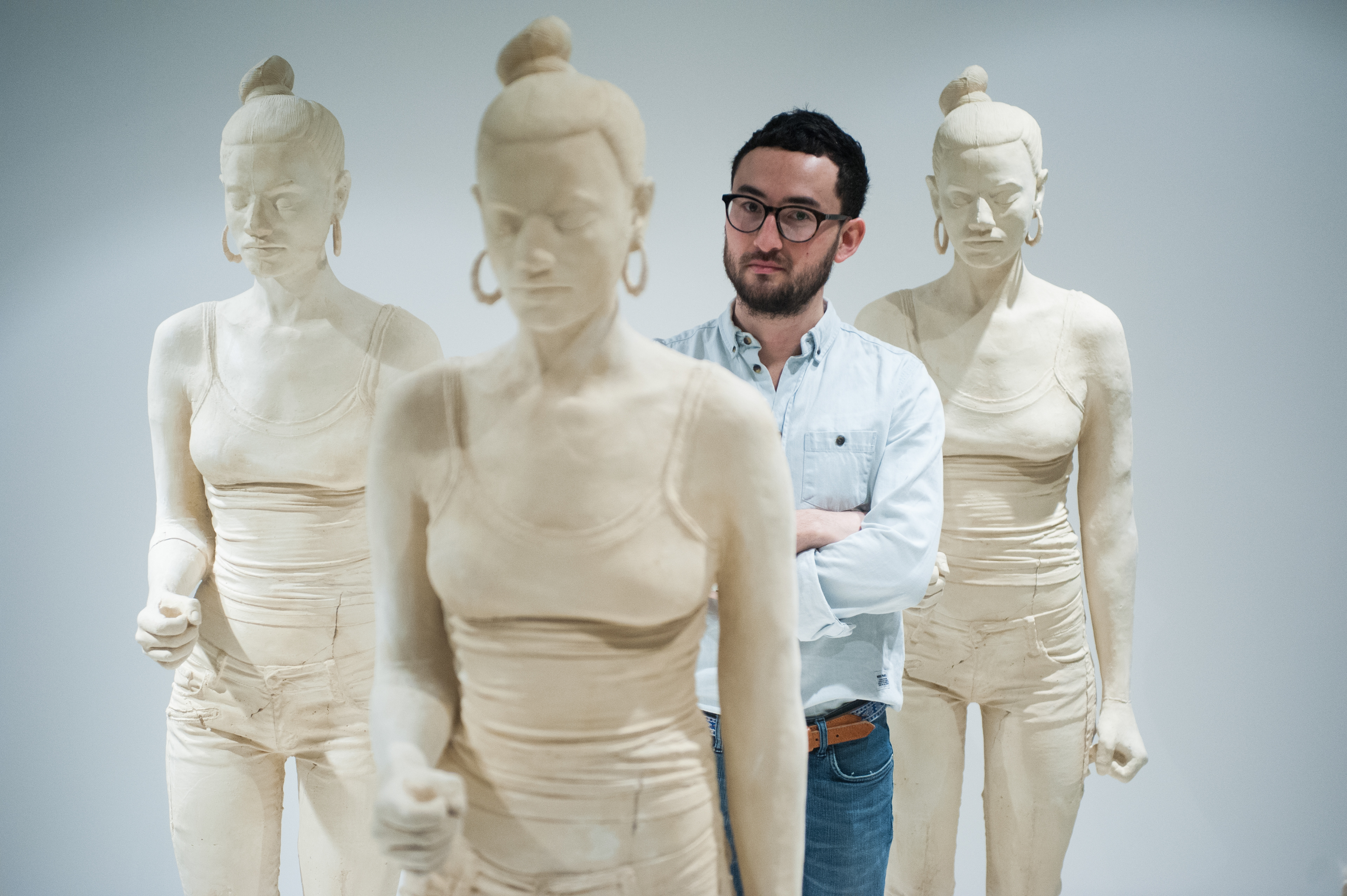London, UK - 29 January 2014: artist Simon Fujiwara poses next to terracotta-dyed life sized plaster casts. His work Rebekkah, comprising 100 terracotta-dyed life sized plaster casts of a 16-year-old girl who took part in the 2011 London riots, goes on display at the Contemporary Art Society until 29 March.  Fotografo a Milano - Photographer Milan