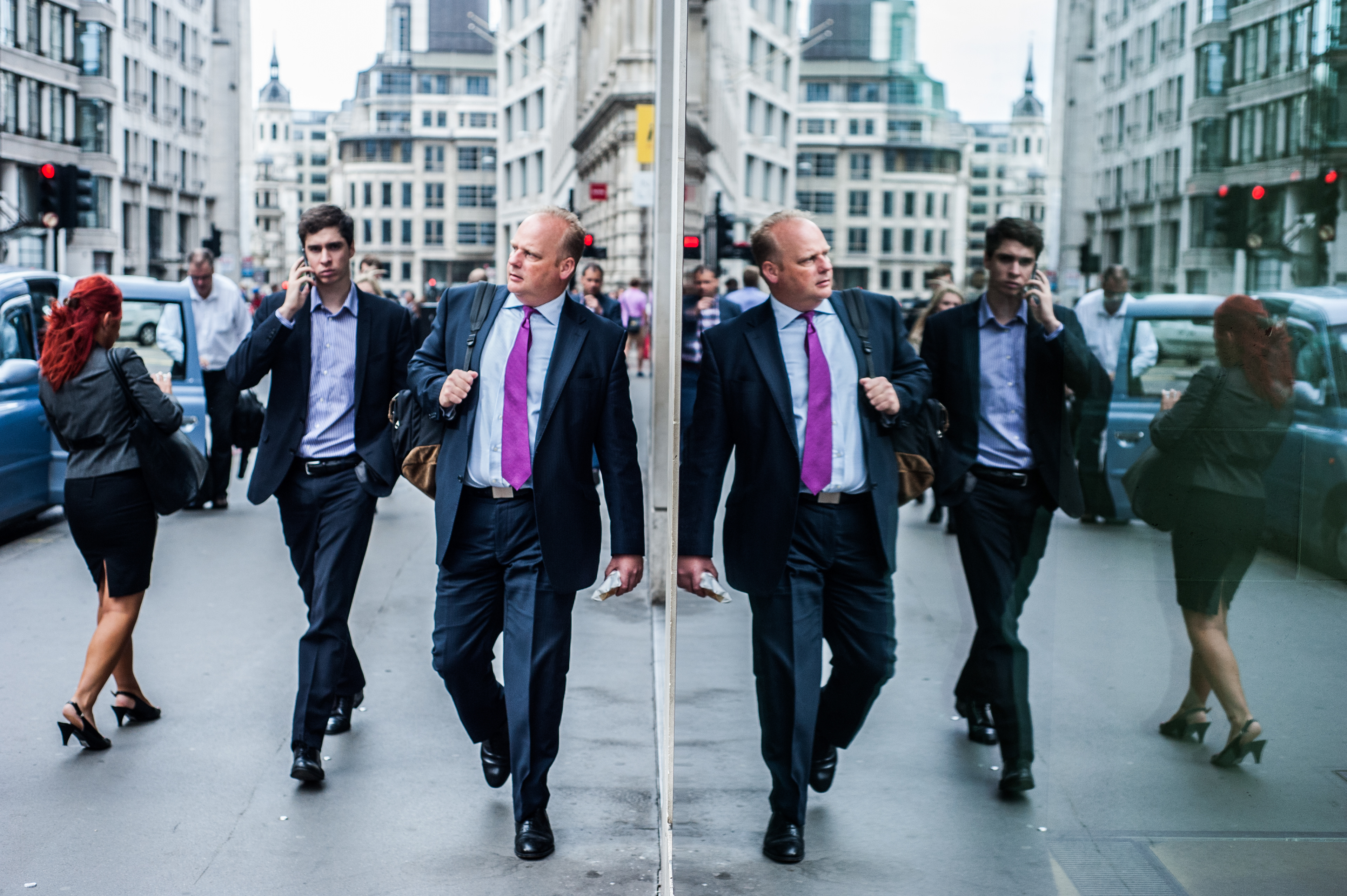 London ,UK - 18 August 2014: a businessman is reflected in a window during the morning rush hour in The City of London