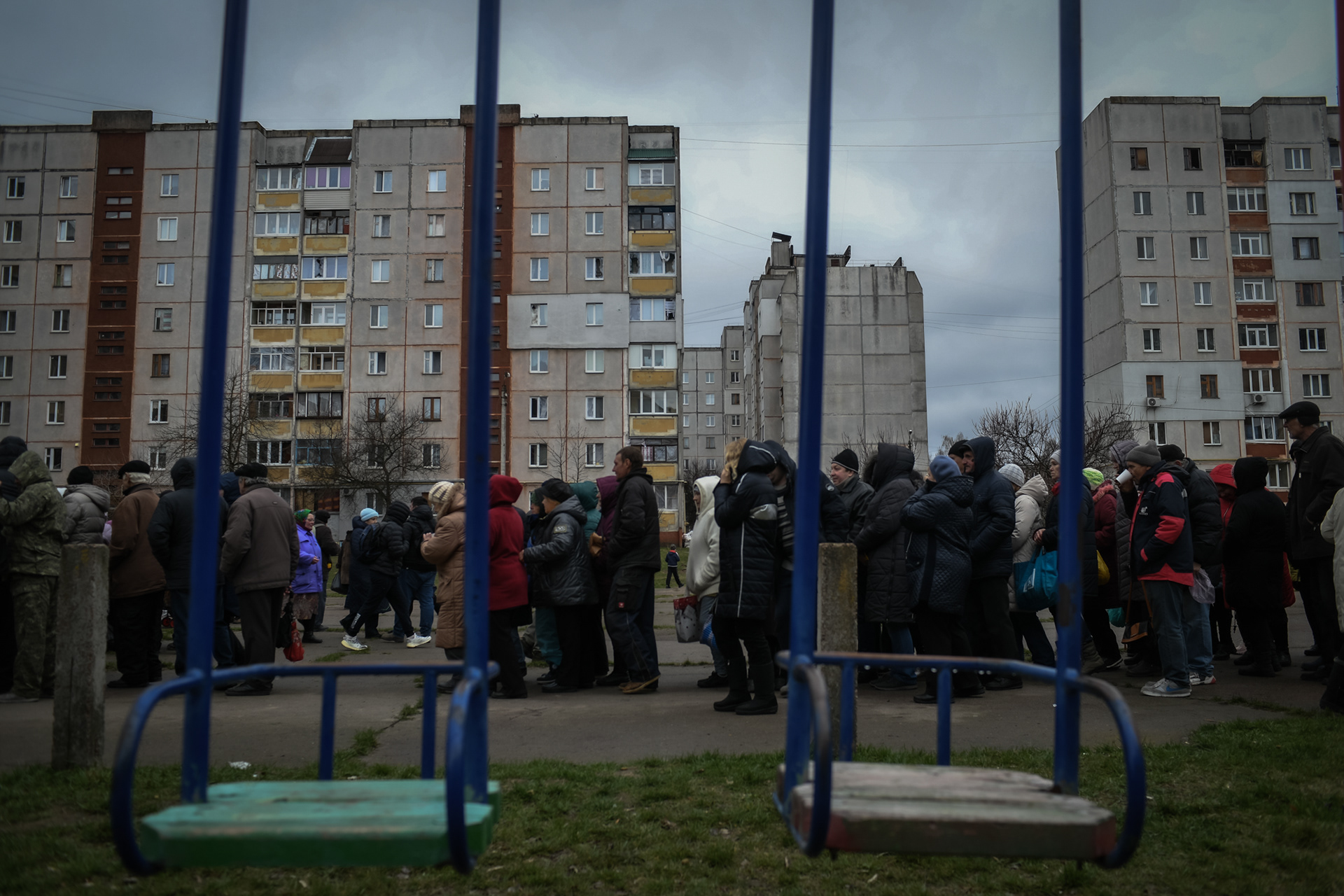 People wait in line for food distribution by an ngo called World Central Kitchen in a residential area of Chernihiv, Ukraine after the Russian invasion on April 16, 2022.