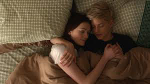 Mae Martin and Kate Ritchie laying in bed together in the show Feel Good