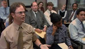 Image from The Office US with multiple characters sat in the conference room