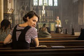 Image of the character of Fleabag sat in a church and turning to us