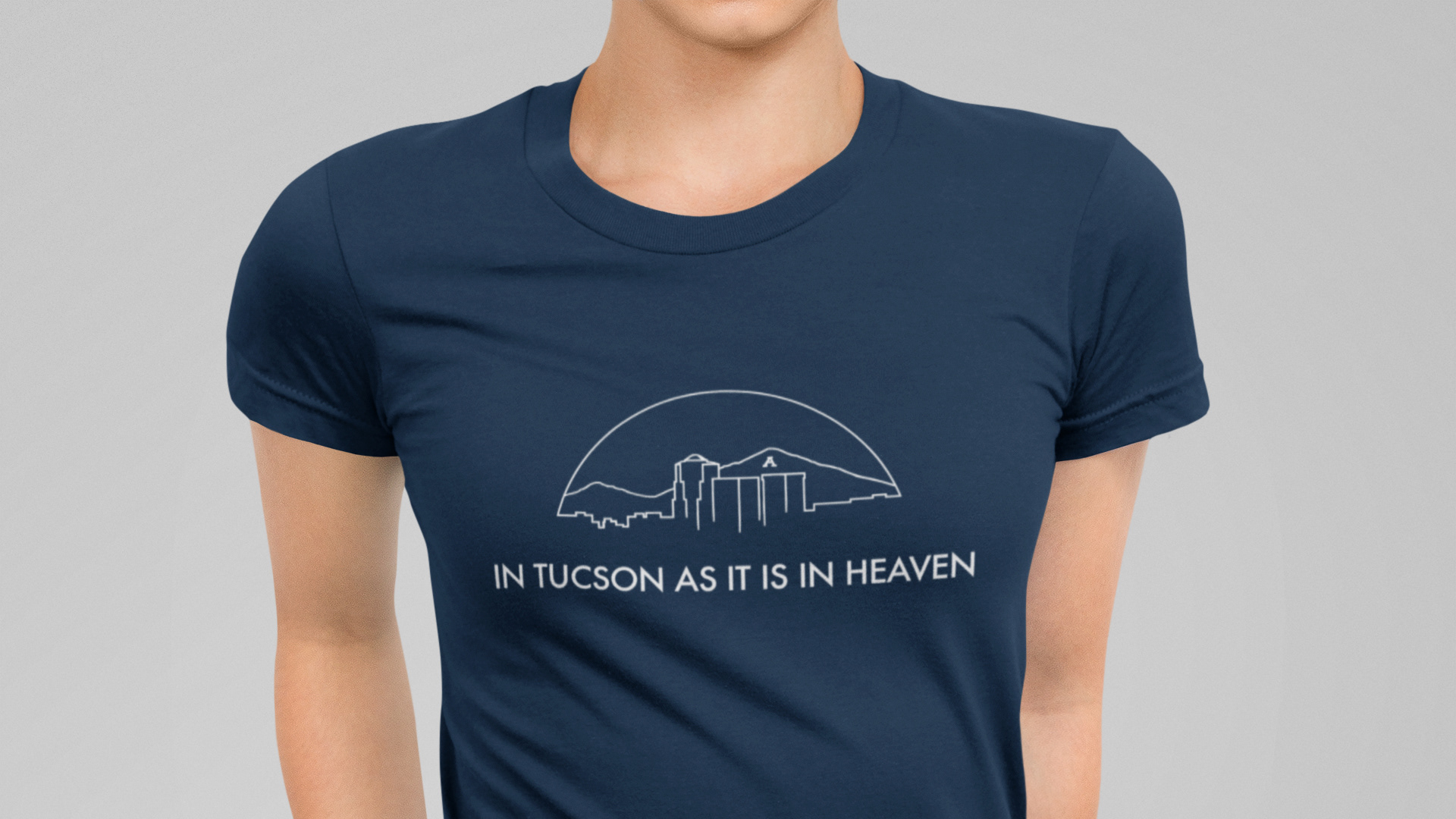 Tucson custom T-shirt design of white line drawing on blue shirt saying "In Tucson as it is in heaven"