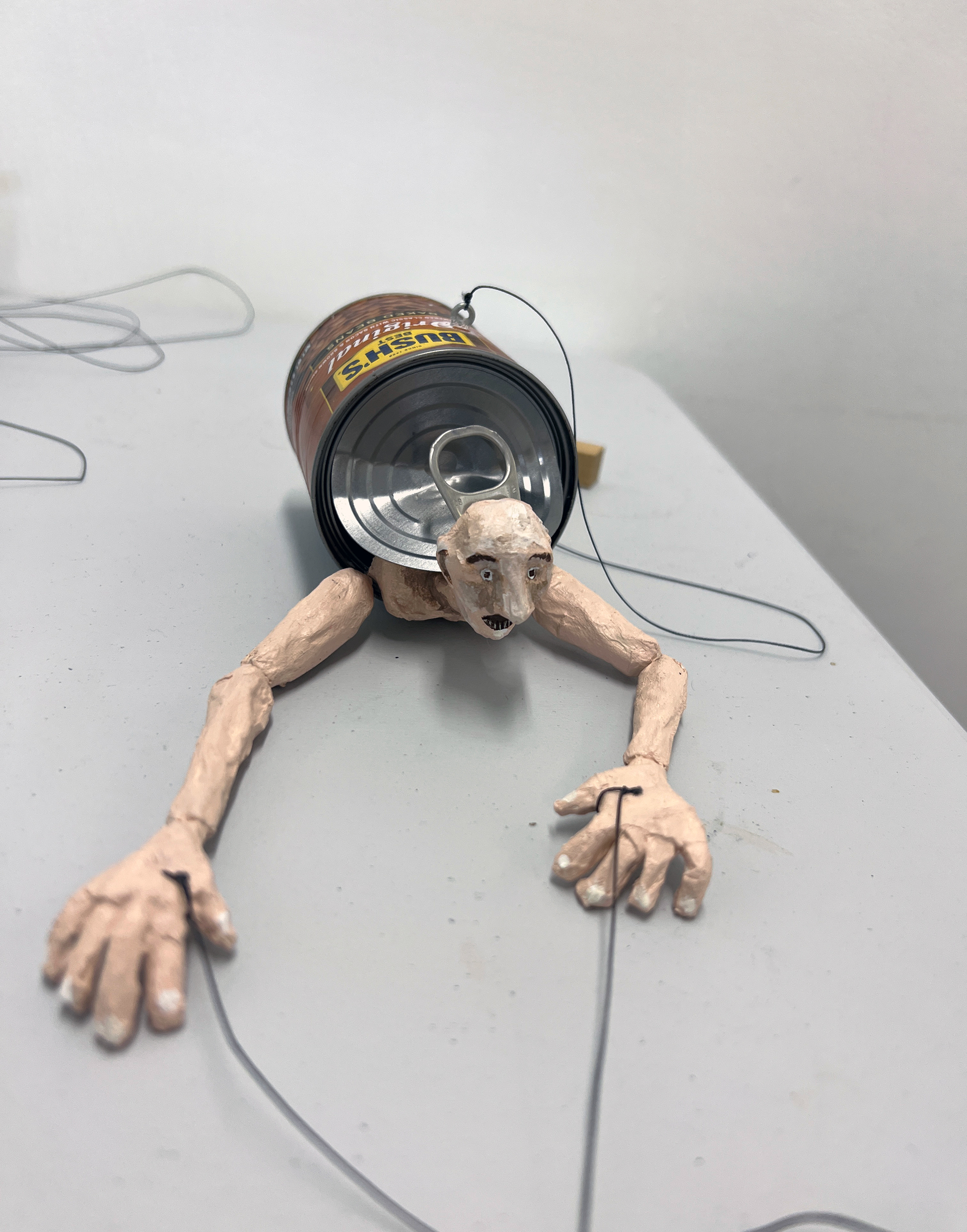 Bean Can Man, paper mache, acrylic, baked bean can, wood, and string, 2022