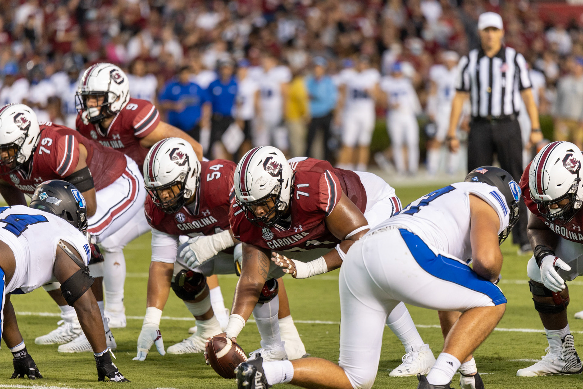 Redshirt senior offensive lineman Eric Douglas hands the ball to graduate student quarterback Zeb Noland at the beginning of the play.