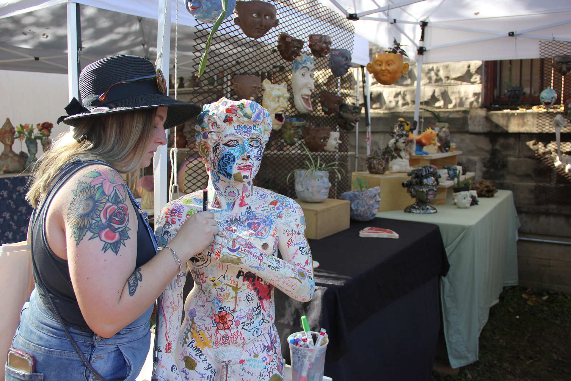Dillman, contributing to the layers of graffiti on this sculpture. Arcidiacono brought this back this activity from the 2017 festival so that guest can leave a message or doodle.