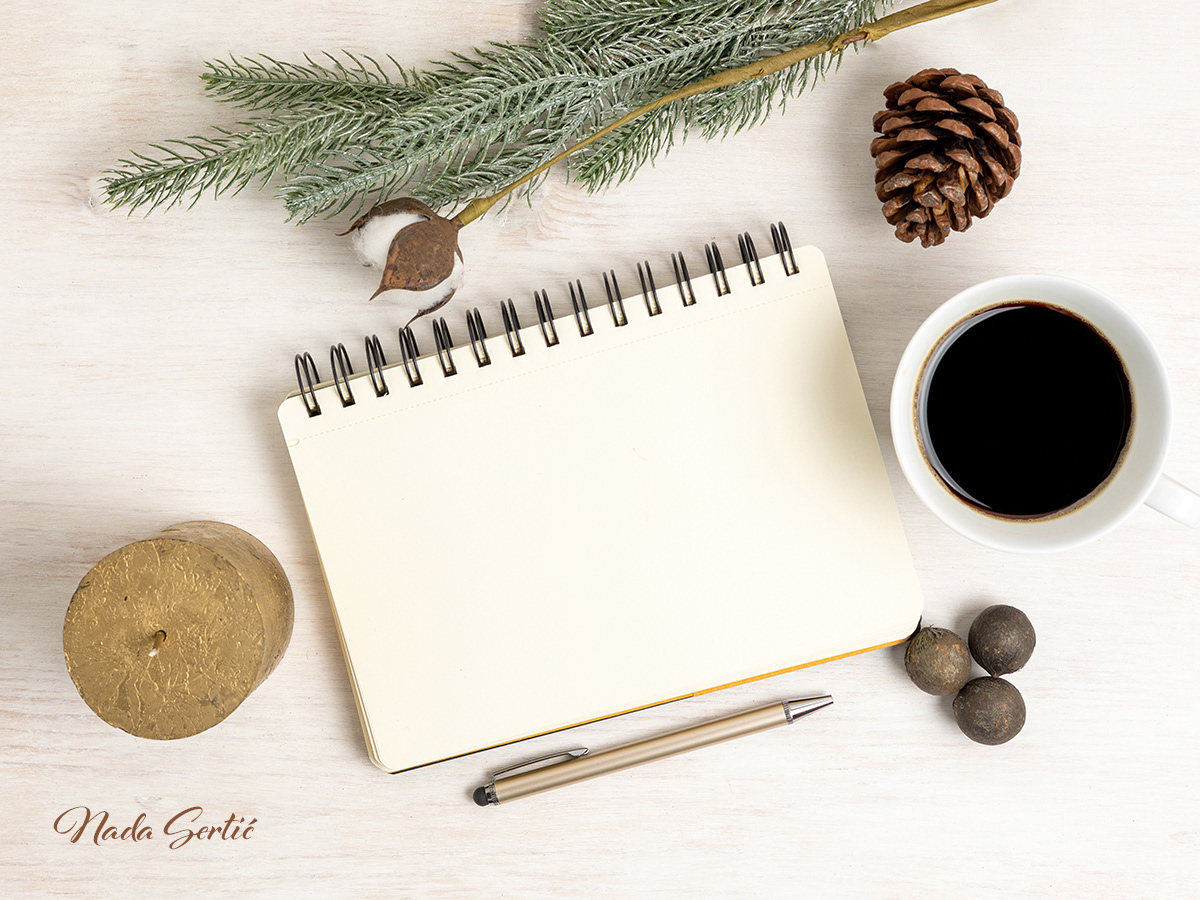Flat lay winter mockup photo with notebook, coffee cup, candle and winter decorations.