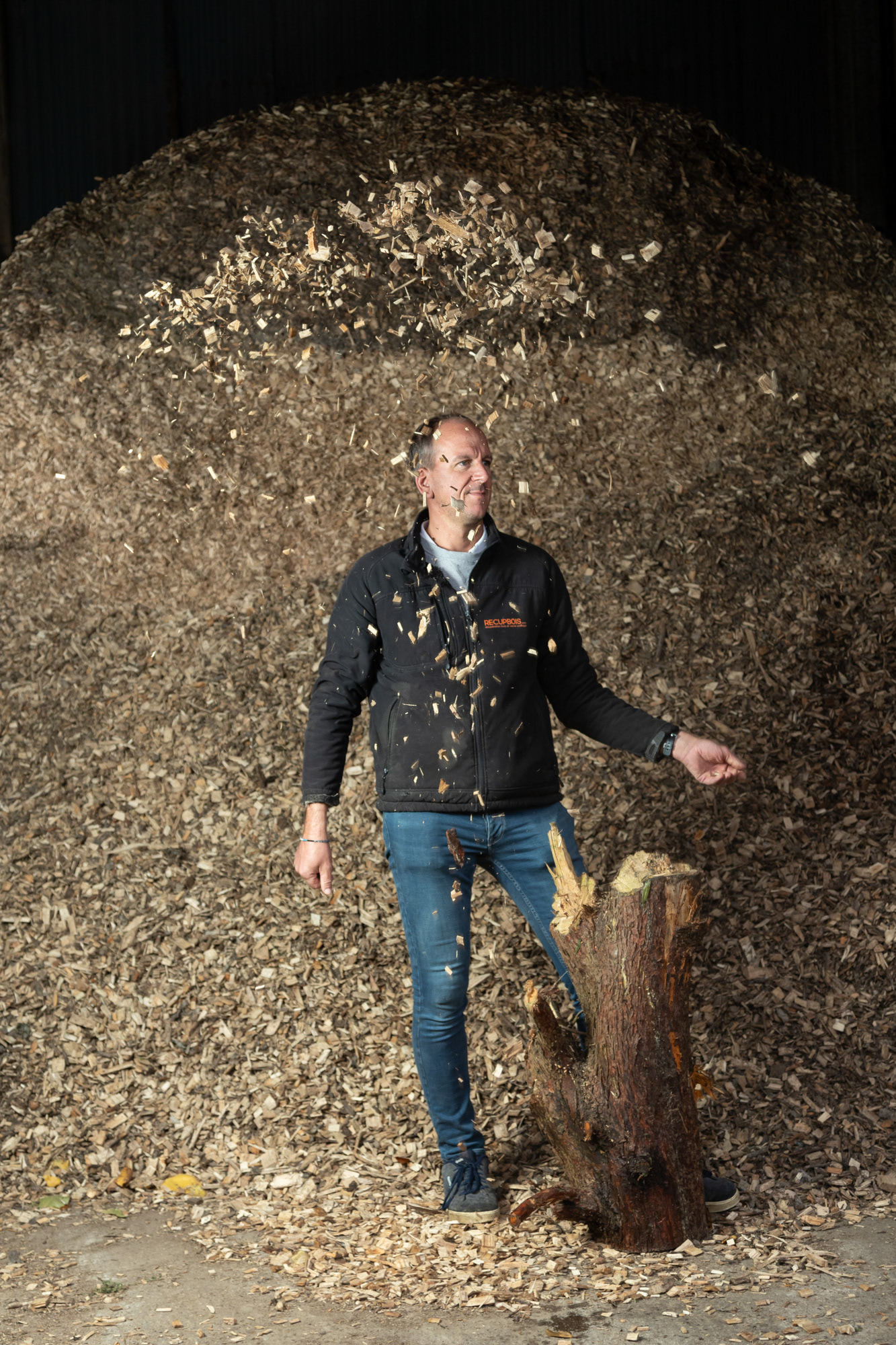 Olivier Larue / Entreprise Récup' bois / Landrethun-lès-Ardres / 12 oct 2023 Un jour où je me promenais j'ai vu une haie qu'on brûlait, pour s'en débarrasser, quel gâchis... A l'époque j'élevais des veaux et je me suis dit que ça serait une bonne idée de réussir à chauffer l'eau qui maintenait le lait à température autrement. J'ai vu une émission sur Las Vegas, en plein désert, des plantes protégées à leur pied par des copeaux de bois, ça a été le déclencheur. On m'a conseillé sur l'installation d'une chaudière à copeaux, je peux y mettre du résineux, tout ce que les gens ne veulent pas. Je les débarrasse gratuitement et je fais des copeaux. Je chauffe toute ma maison et je revends en gros ou en détail des copeaux aux particuliers, aux entreprises, etc. Avec l'interdiction des herbicides pour les particuliers, ça a marché tellement bien que j'ai arrêté l'élevage, ça me laisse plus de temps pour aller faire de la planche à voile !