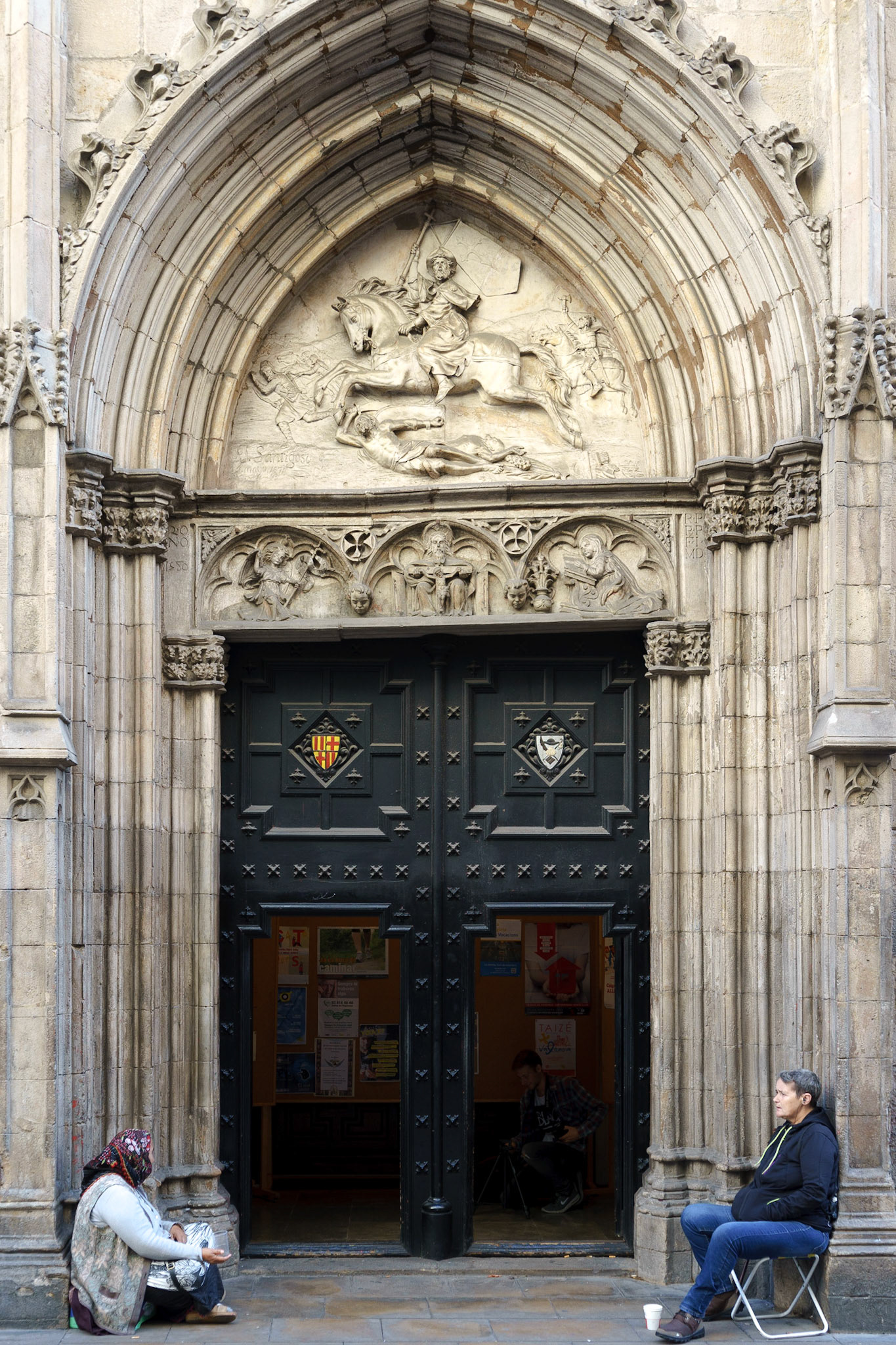 Barselona'daki bir kilisenin kapısında karşılıklı oturan iki dilencinin ilginç görüntüsü.