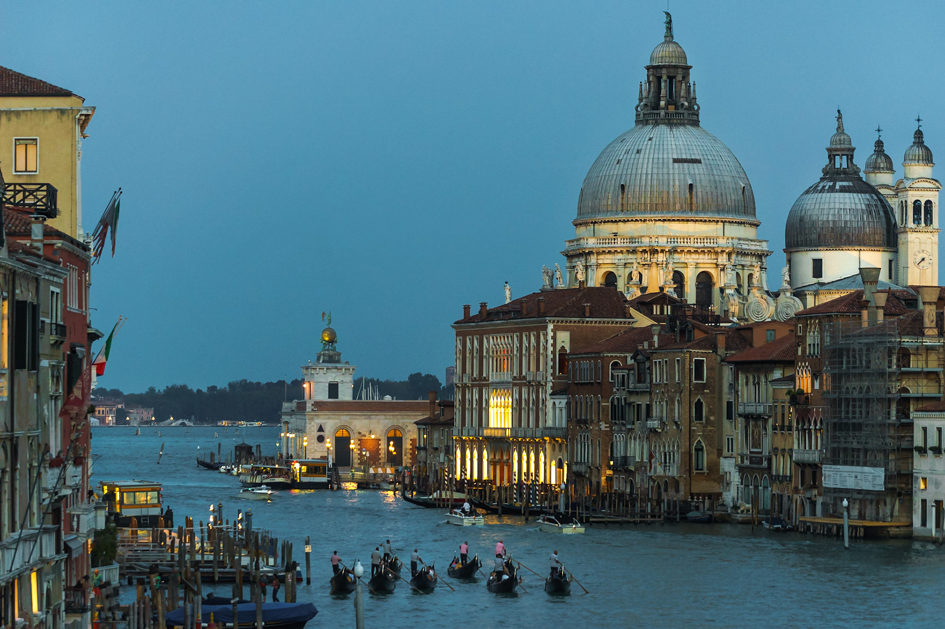 Accademia Köprüsü üzerinden, bir gondol etkinliği ile birlikte arka plandaki Santa Maria della Salute Bazilikası'nın görüntüsü.