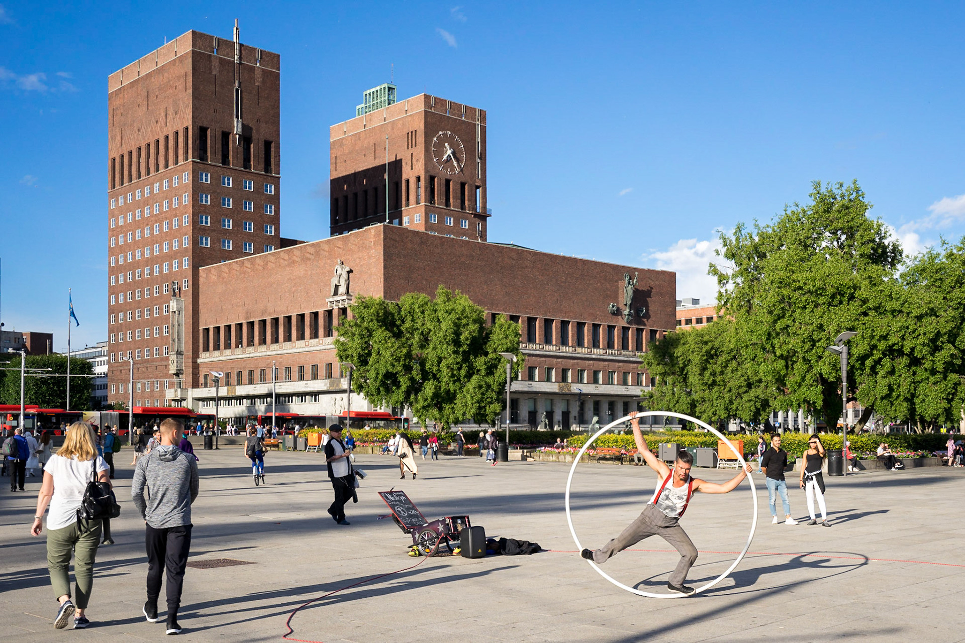 Oslo limanının bitişiğinde yer alan belediye binası ve etrafındaki sokak sanatçıları.