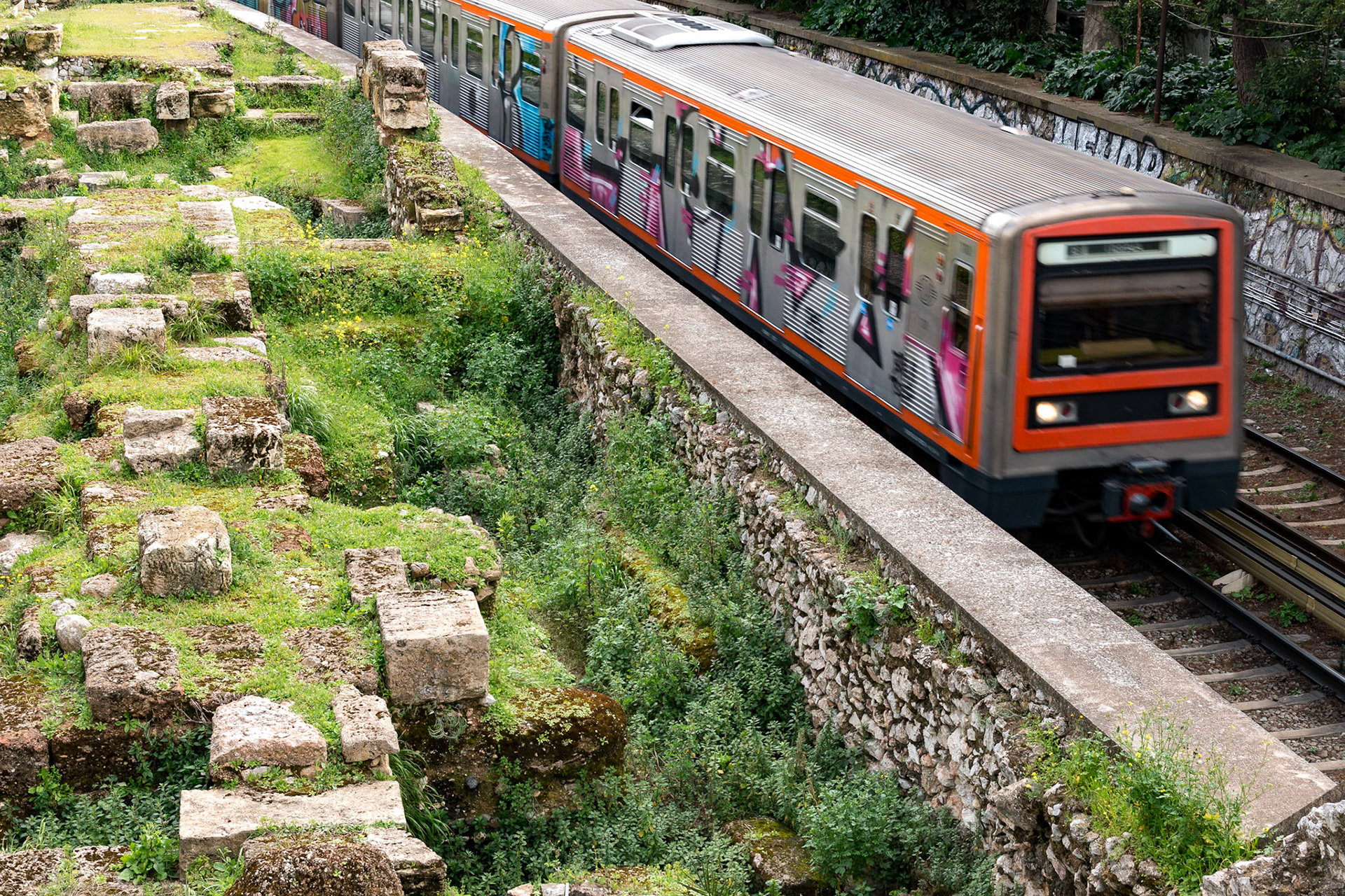 Bir tarafta Antik Yunan döneminden bina ve anıt kalıntıları, diğer tarafta şehir metrosu ile tipik bir Atina görüntüsü. Atina, tarihin bittiği, modernliğin başladığı noktanın anlaşılmasının güç olduğu bir şehir.
