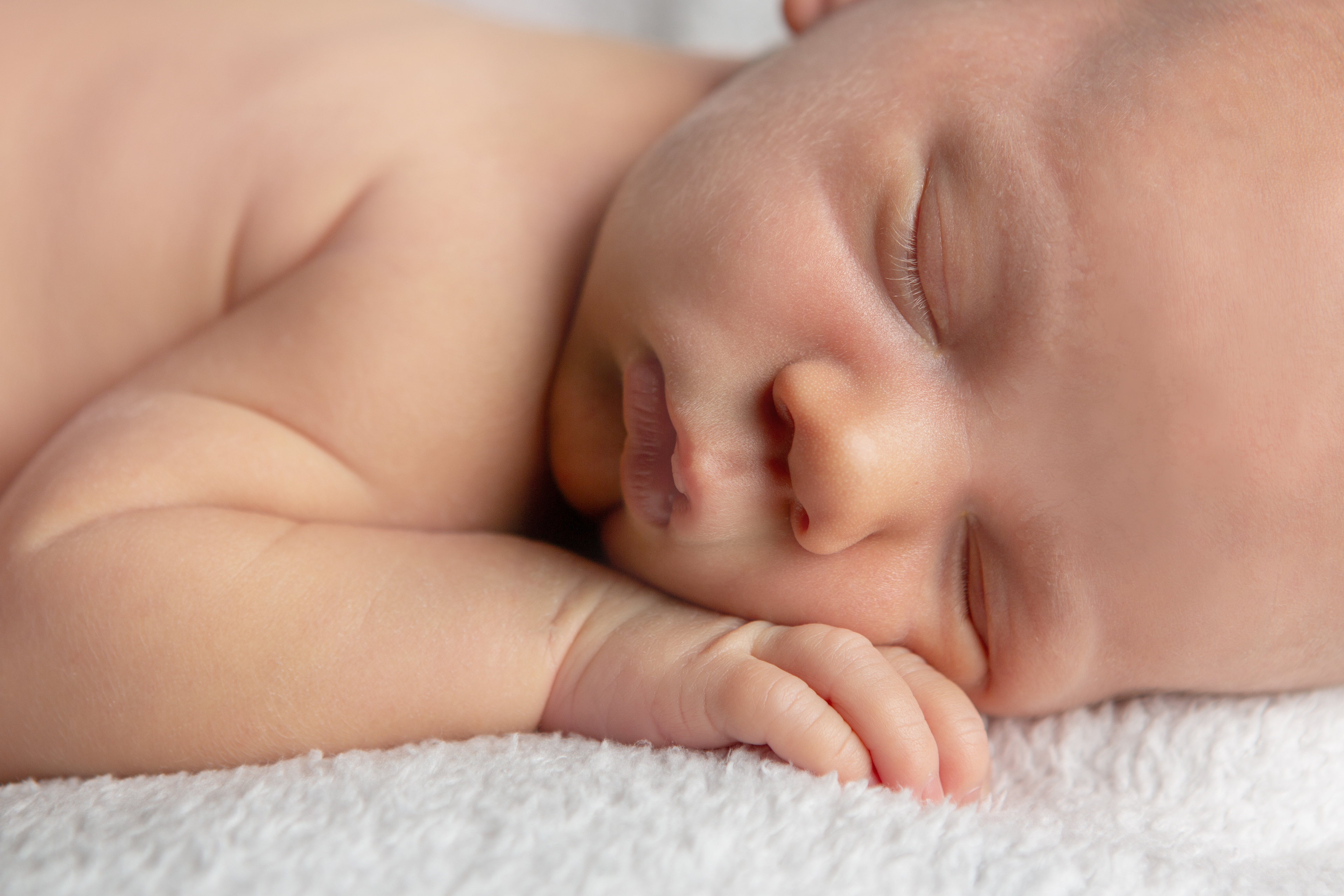 Close up of sleeping baby's face and tiny hand