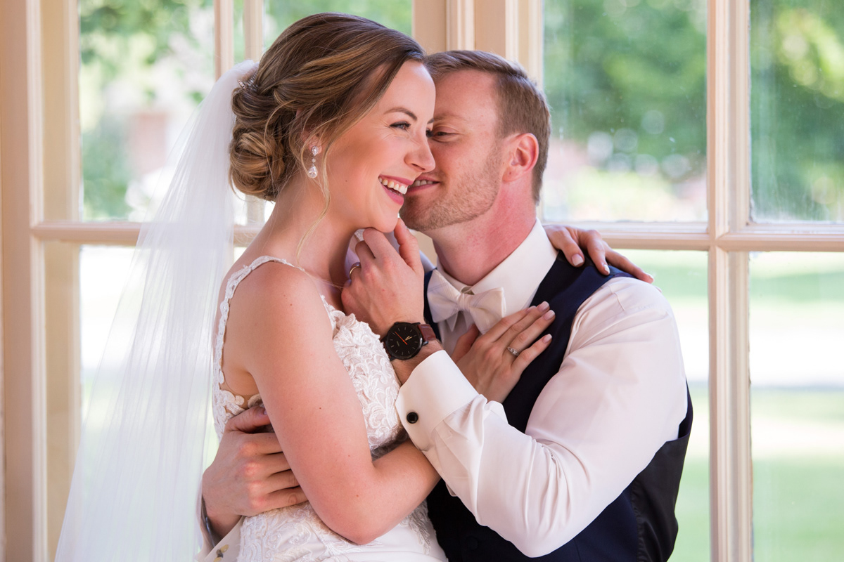 Groom whispering into brides ear