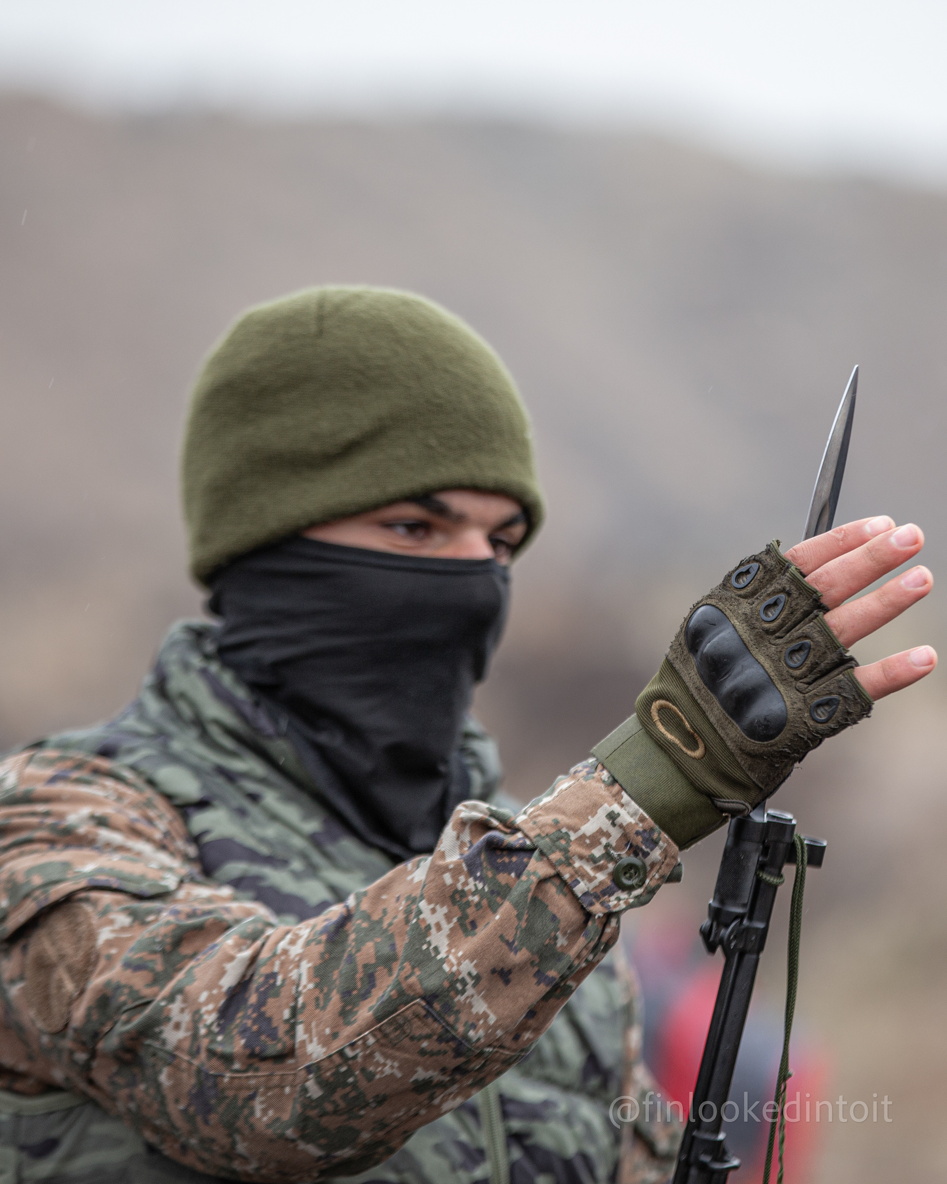 An Armenian member of the Metsn-Tigran militia inspects his freshly sharpened bayonet, 11/05/2021