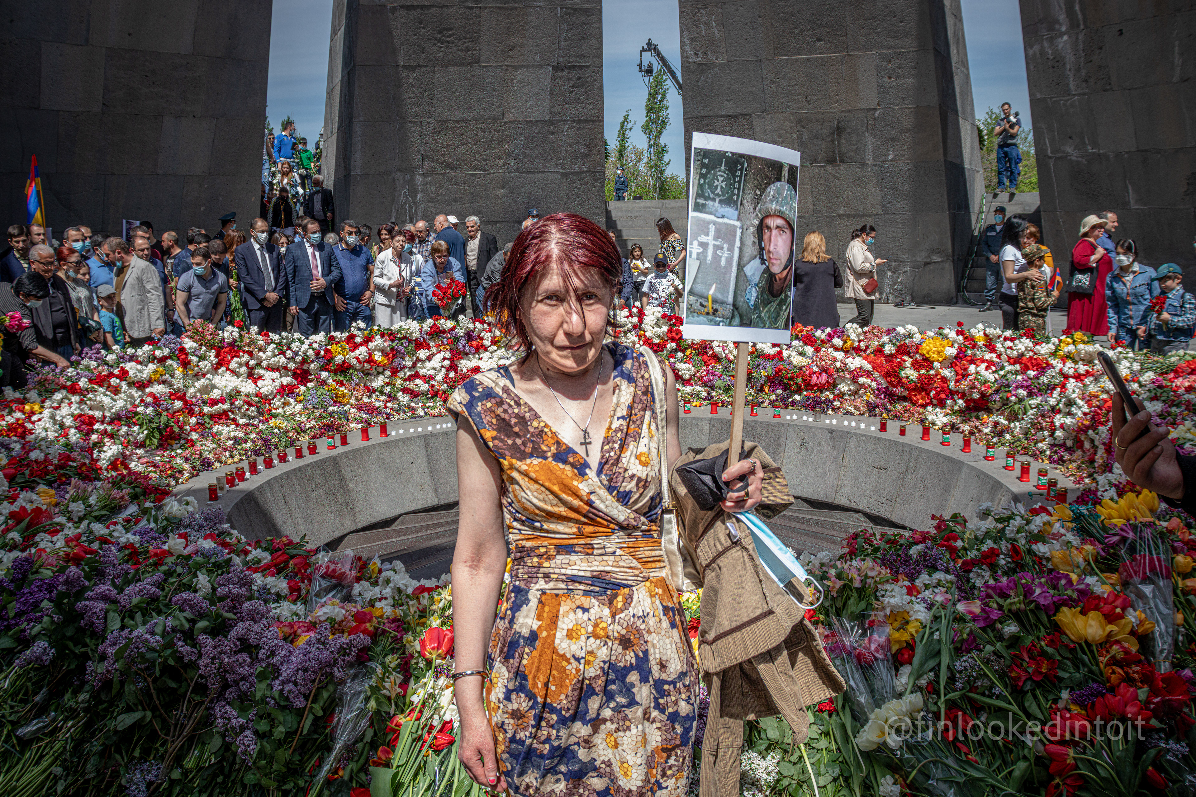 An Armenian woman holding a sign with her slain son next to the Armenian genocide memorial in Yerevan, 04/24/2021